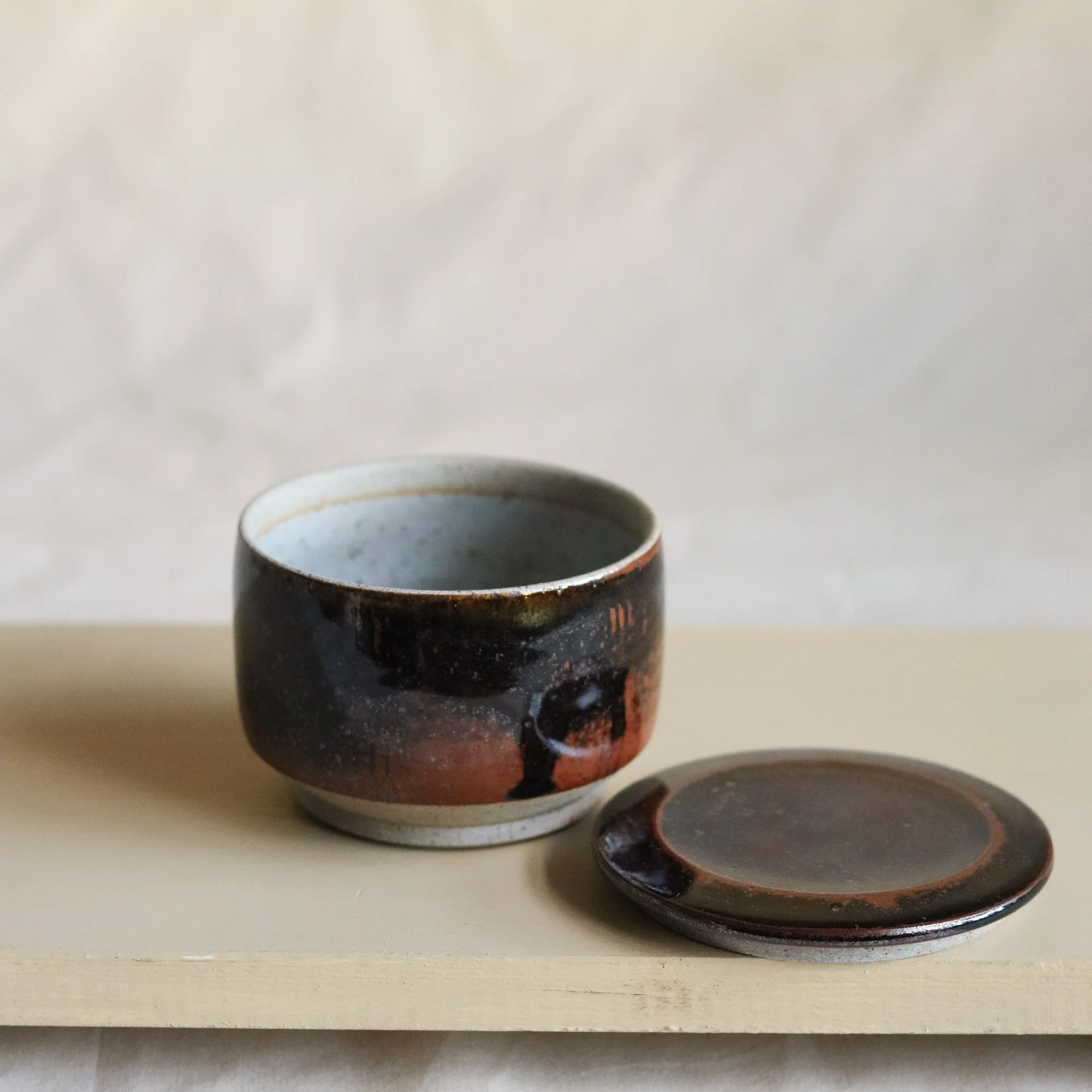 Lidded jar in tenmoku hand thrown in Sheffield by Pottery West