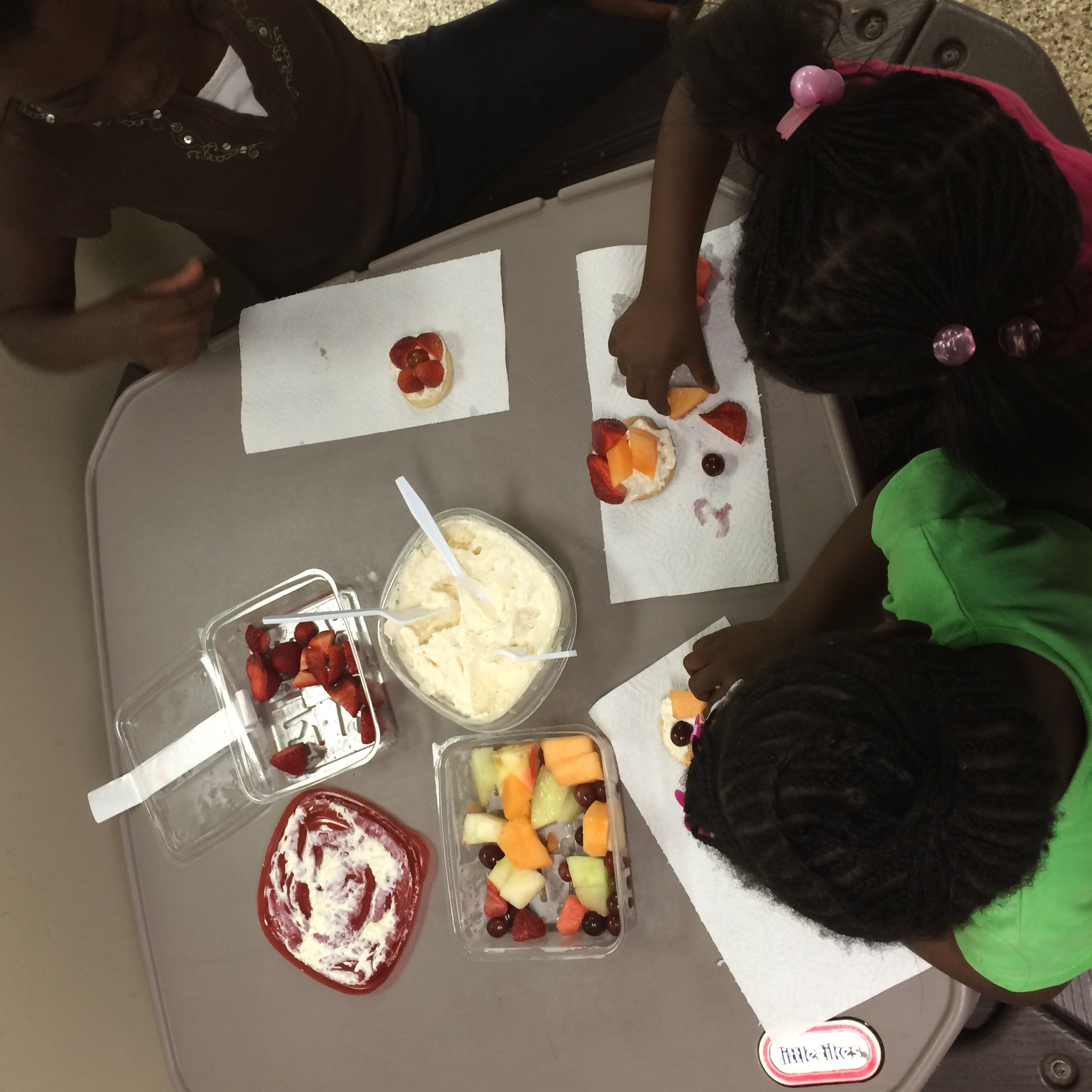Children make fruit pizzas at the Farm to Table Fun station at Central Pantry.