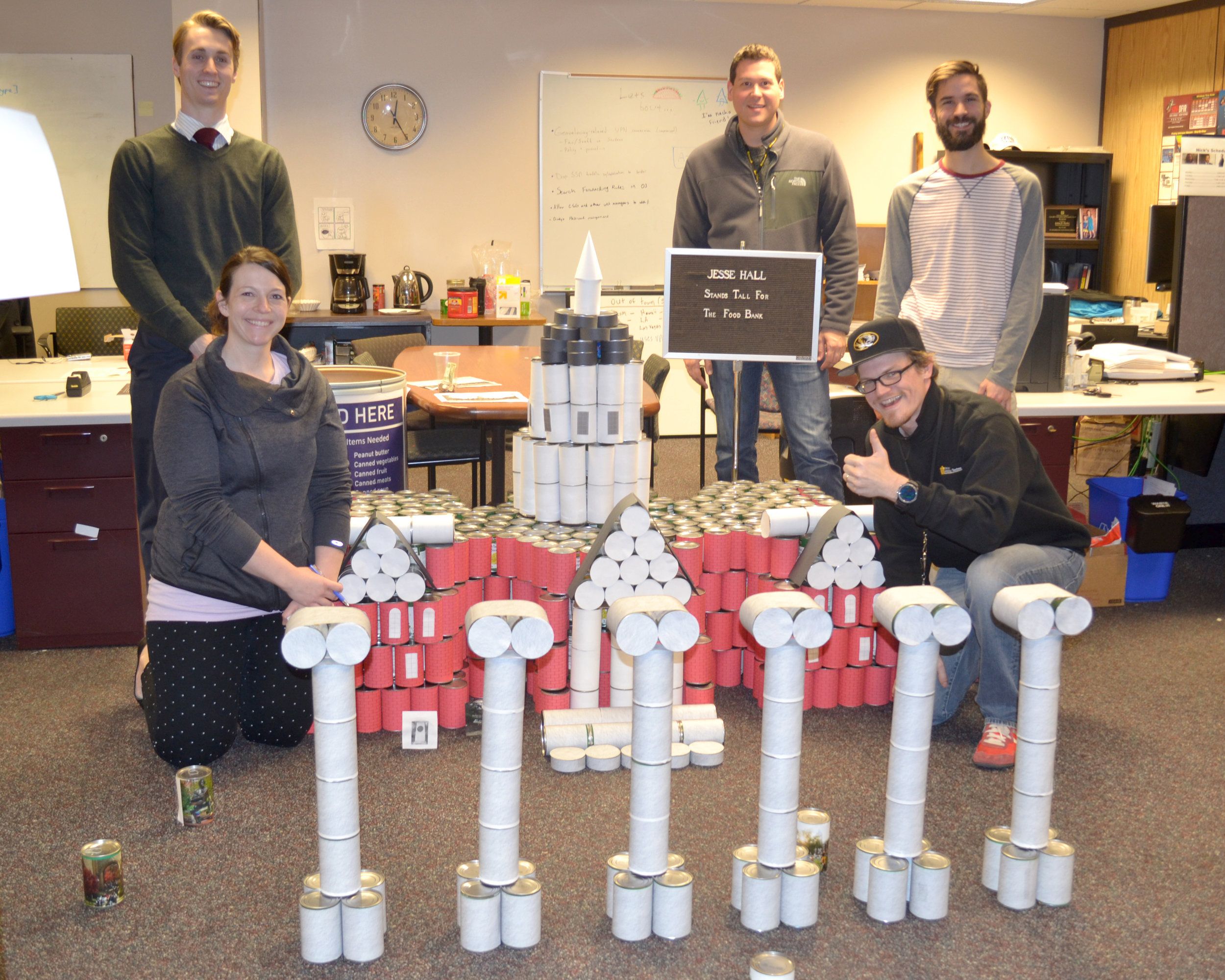 The winning team with The Food Bank staff shows off its canned replica of Jesse Hall.