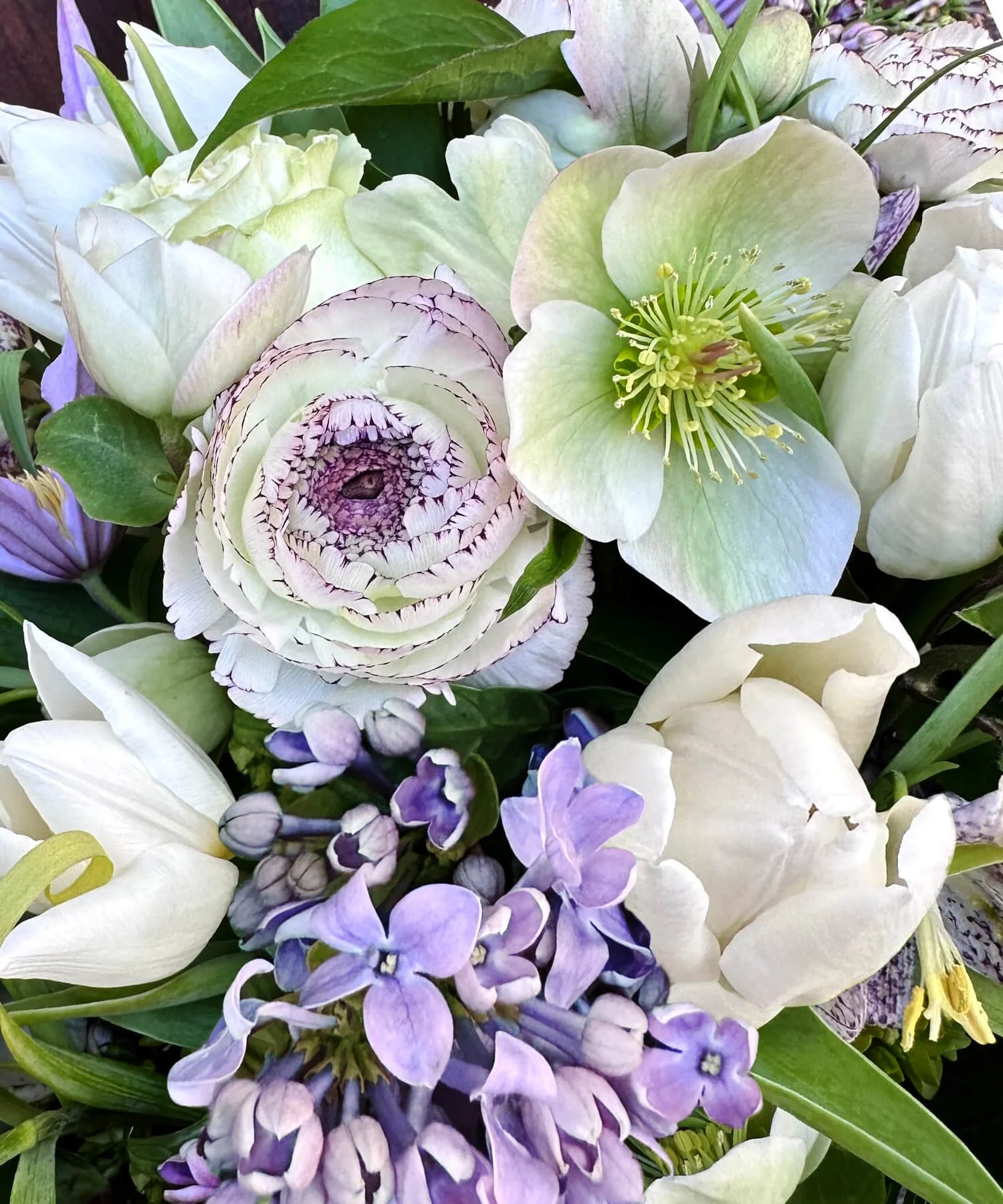 Soft and welcoming spring floral arrangement including peonies, tulips, and snap dragons.