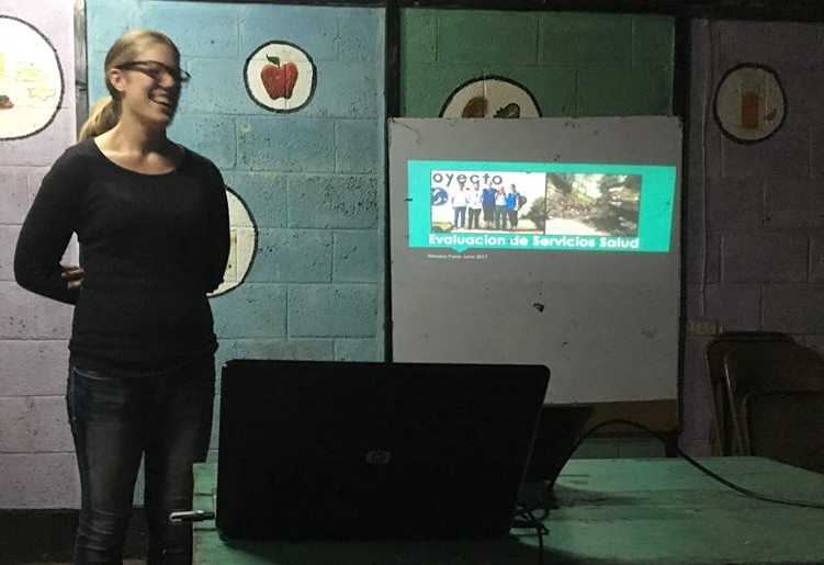 Volunteer Arielle presents the findings of her healthcare services assessment to Primeros Pasos staff.