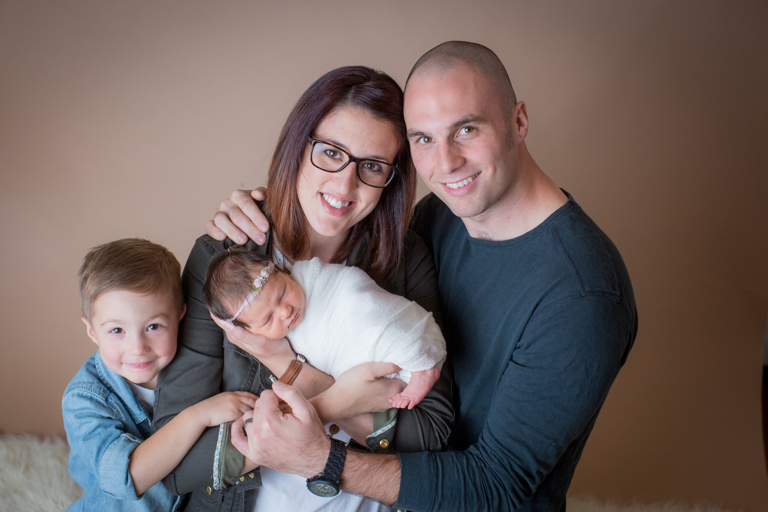  studio baby photography with mom, dad, and brother with newborn baby in davison michigan 