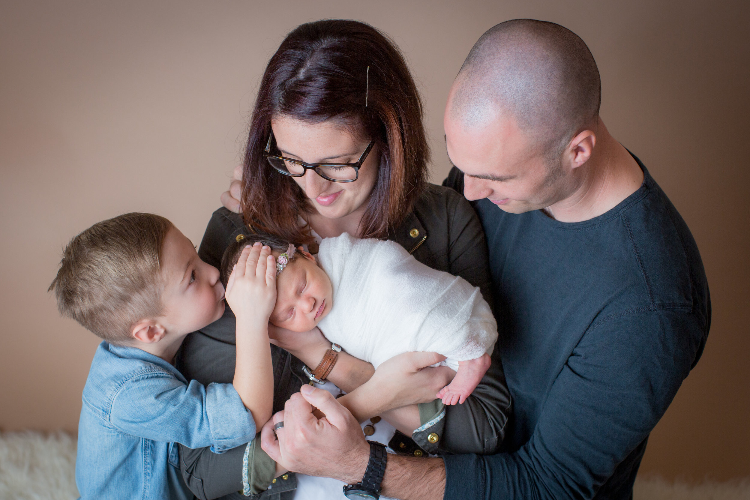  Davison Michigan newborn portrait photographer with a family and baby, brother kissing baby 