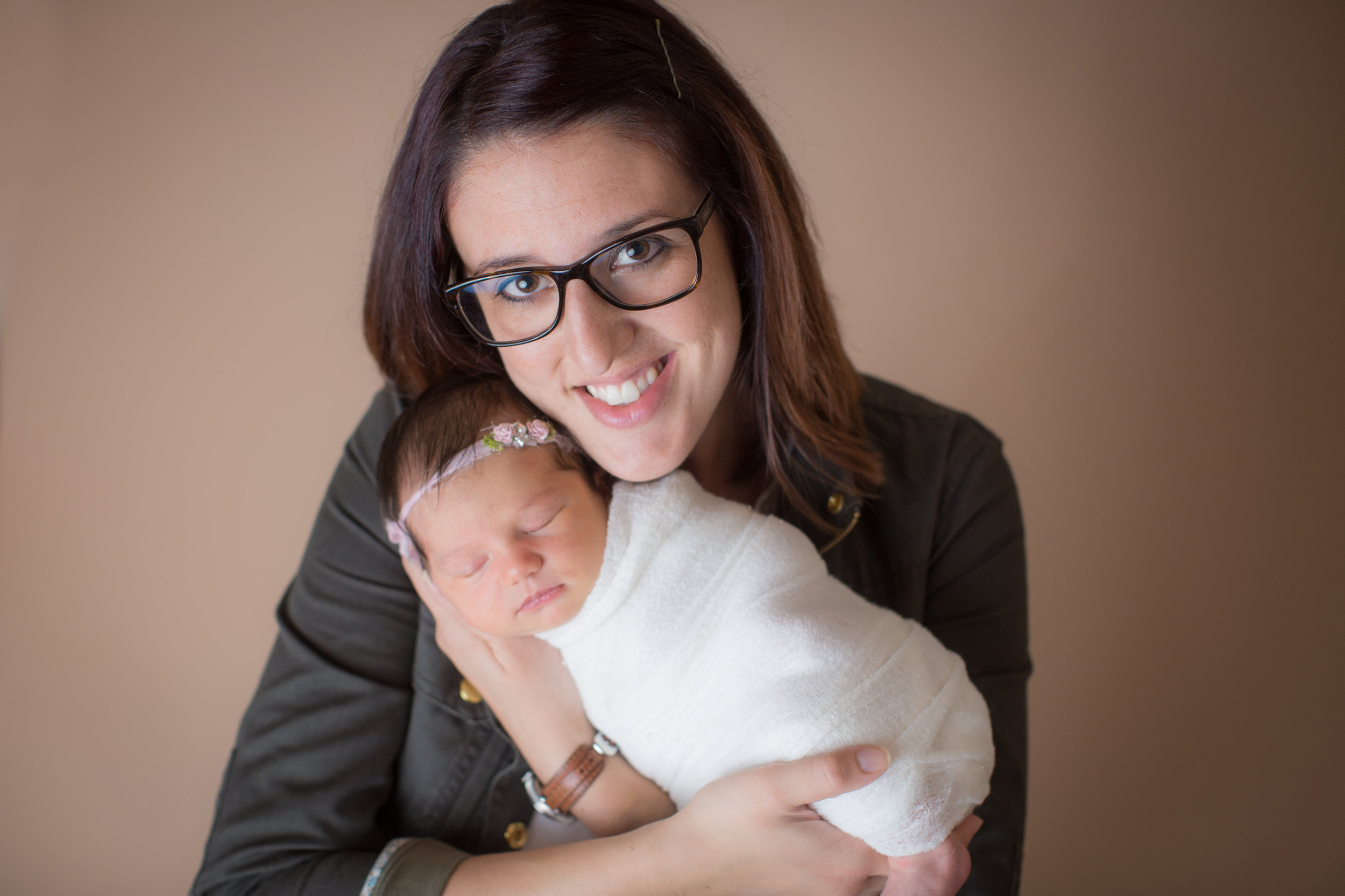  mom smiling with new baby and posing for the best photographyin davison michigan 