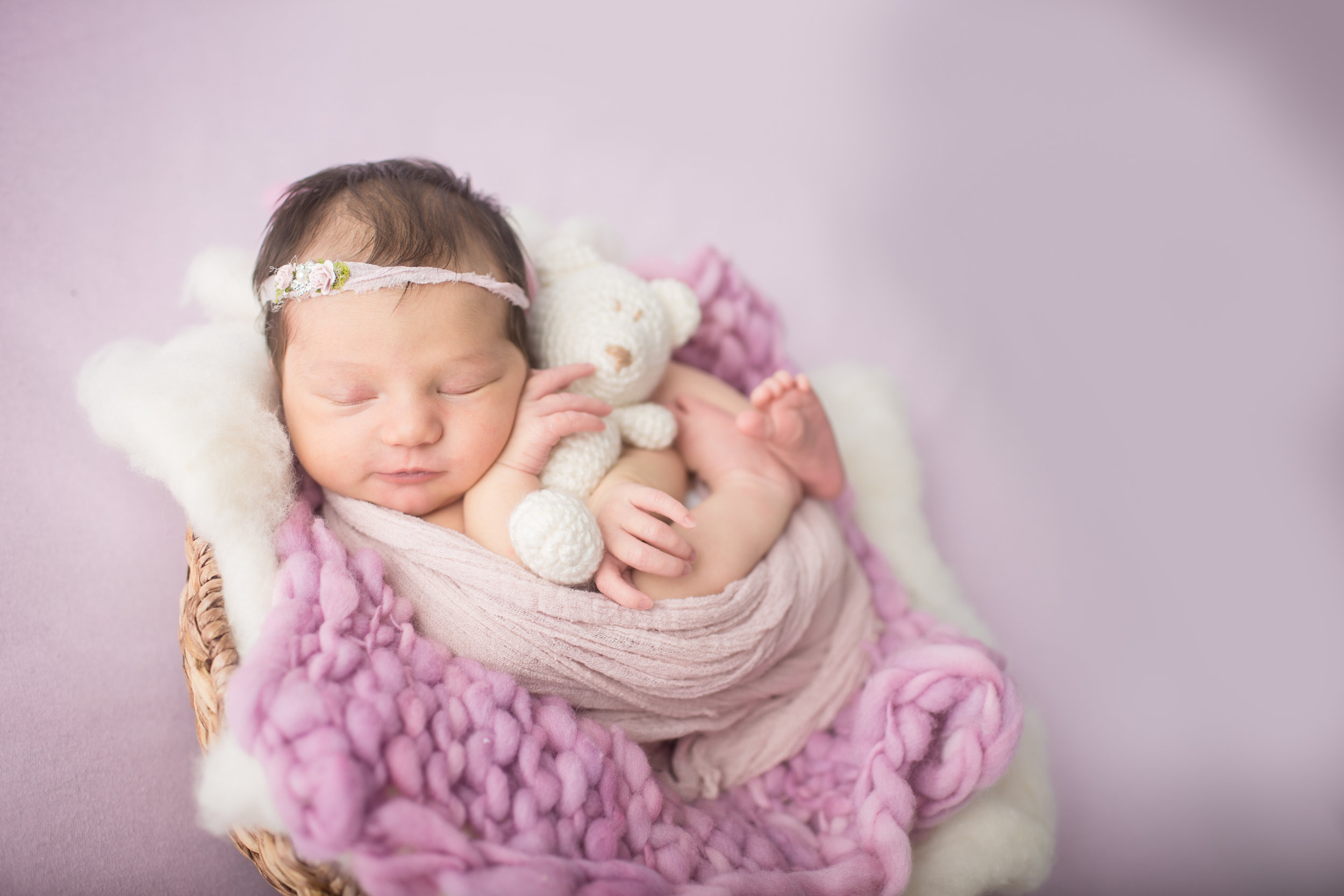  Davison Michigan newborn portrait photographer posing a newborn girl with teddy bear at her studio photo shoot 