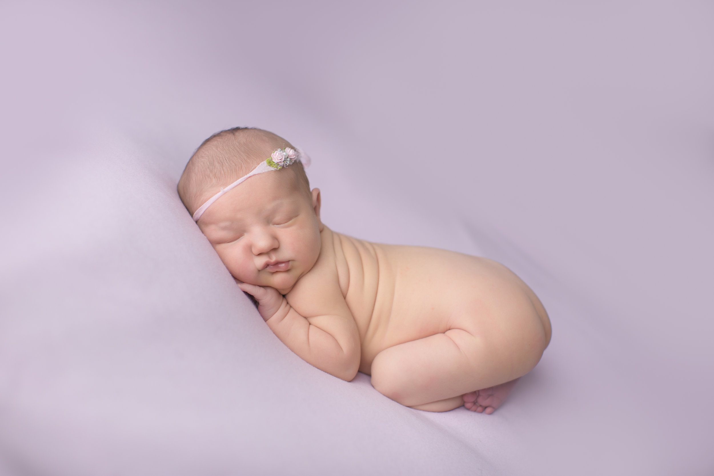  newborn baby photo with baby laying on purple in fenton michigan 