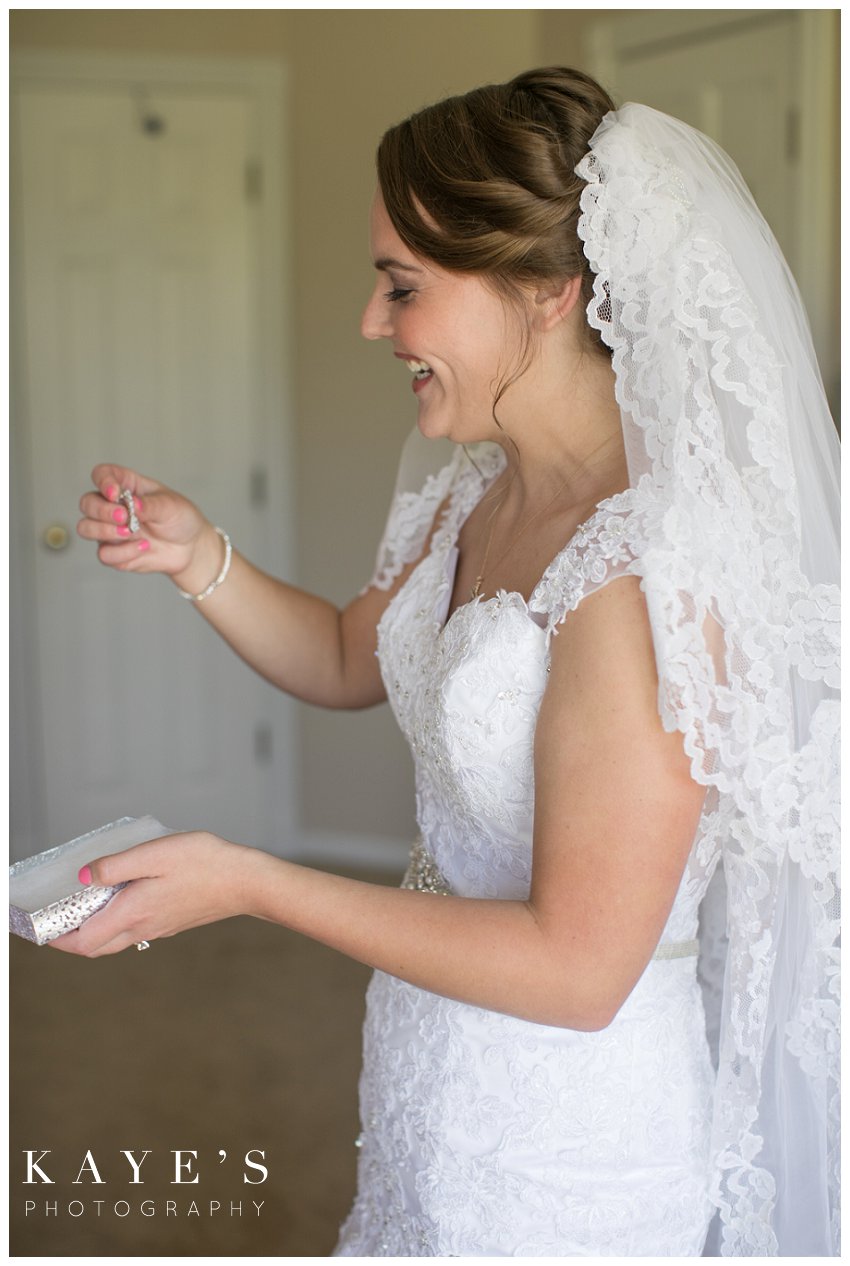 Bride opening her gift from her groom in Flint Michigan during wedding