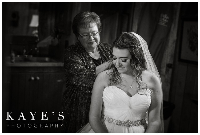 grandmother putting on necklace in bridal suite in ann arbor michigan at misty farms