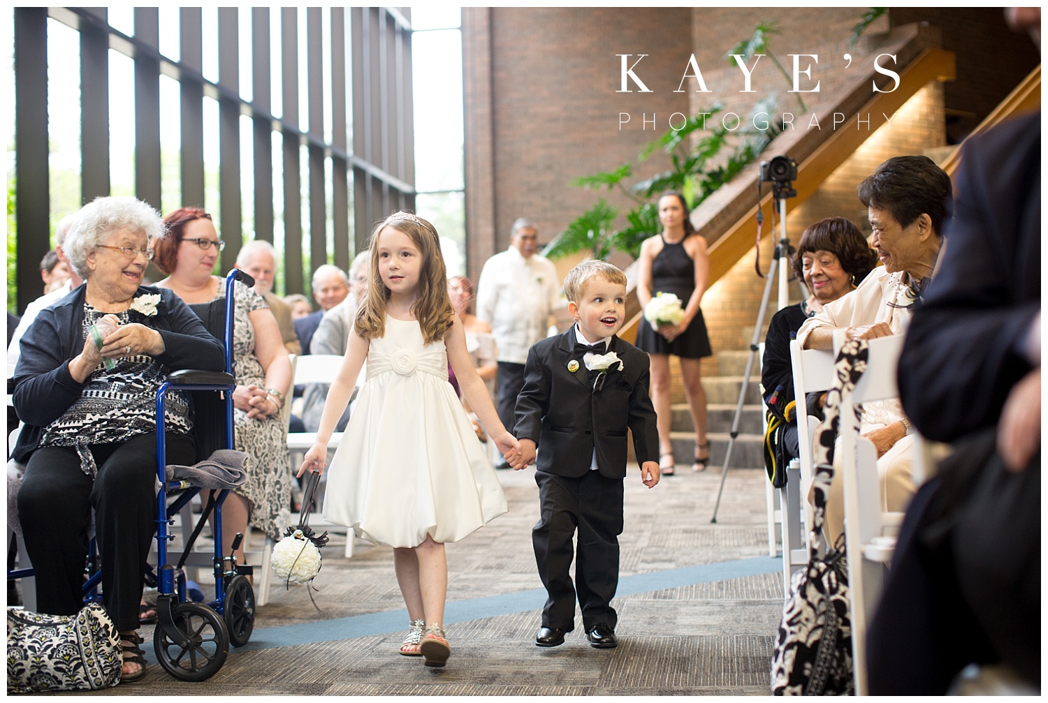 ring bearer and flower girl going down the aisle during the wedding ceremony at university of michigan wedding