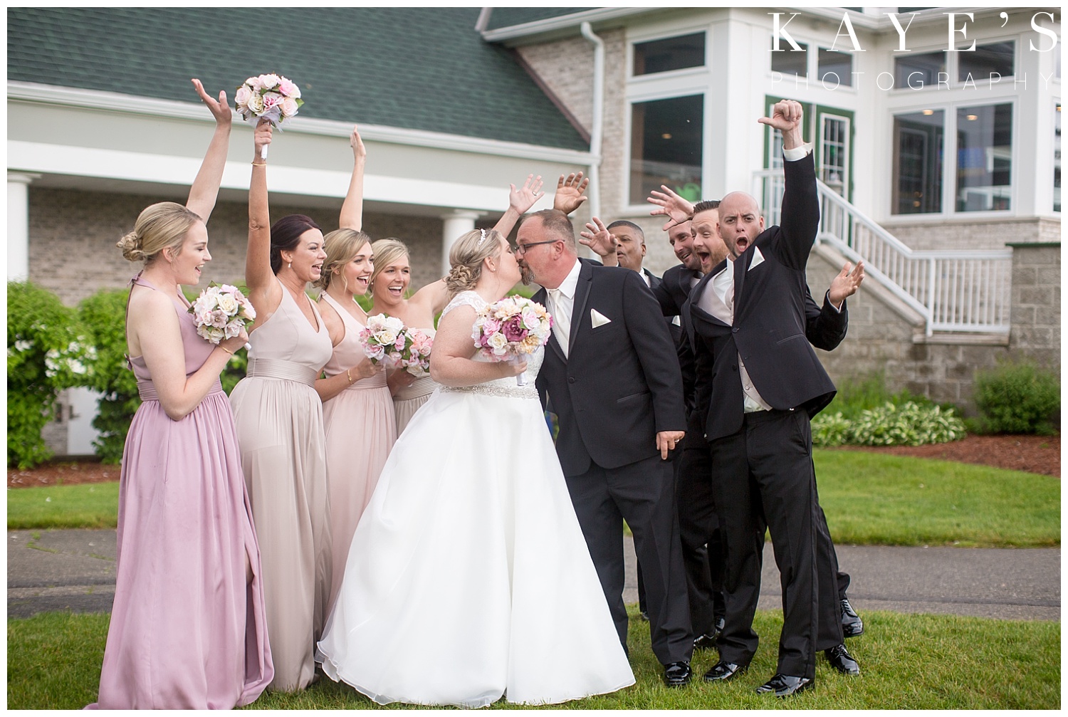 bridal party photos with bride and groom kissing