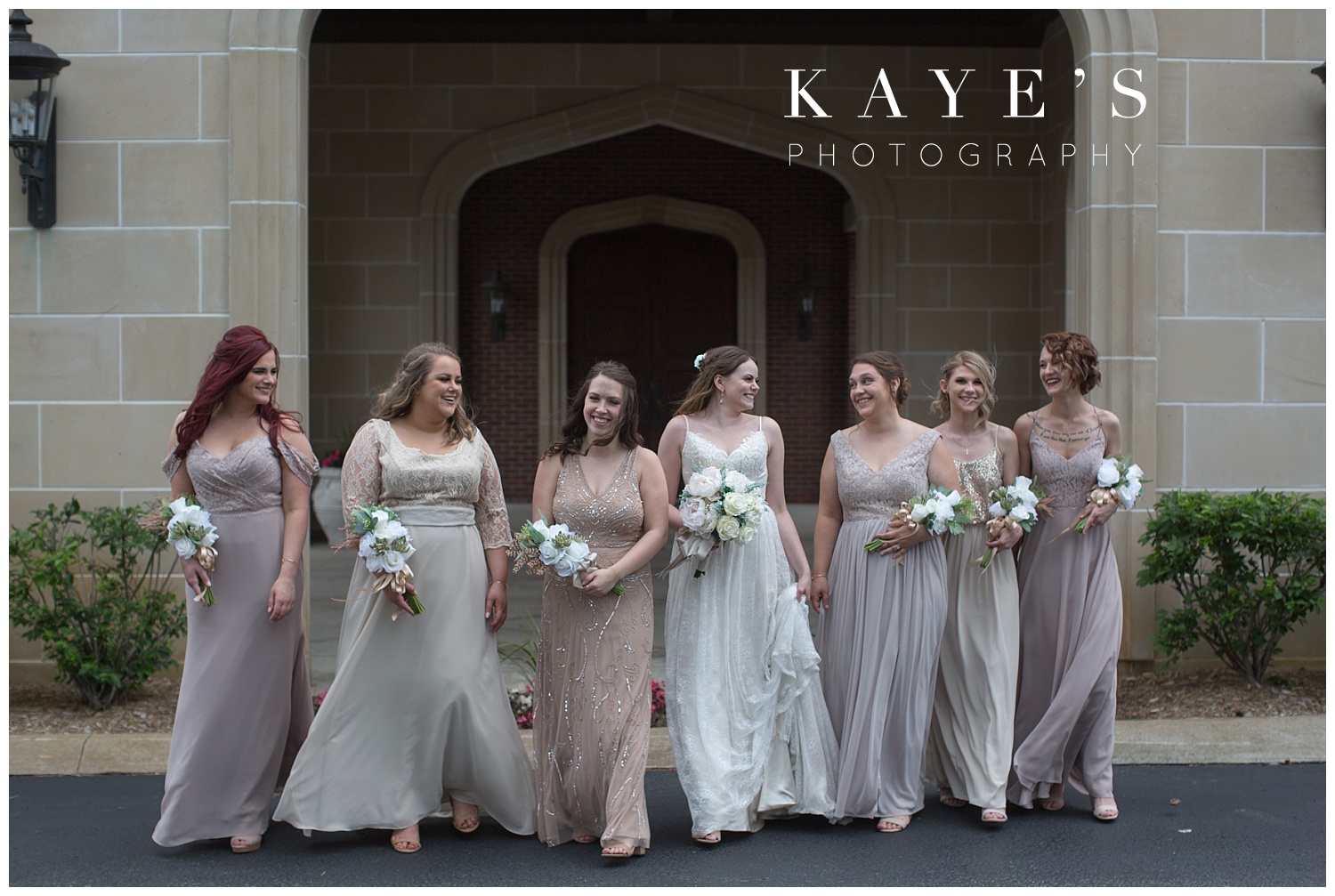 bride with bridesmaids walking in front of warwick hills in grand blanc michigan