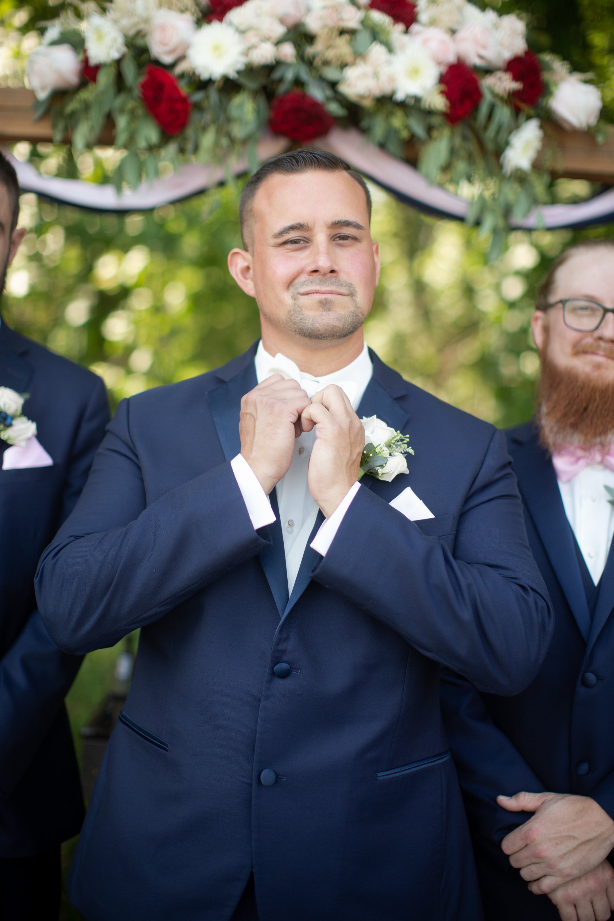 groom in navy suit during groom portraits by Kaye's Photography