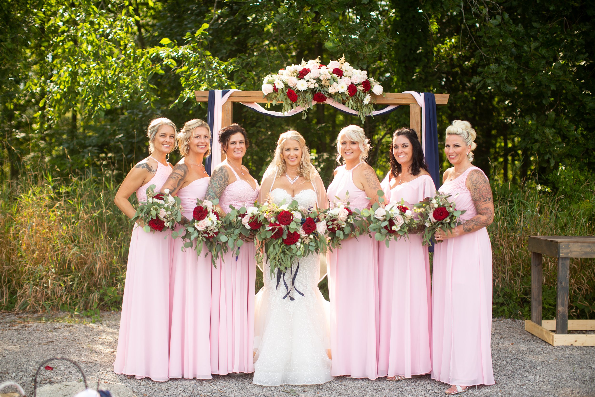bride with bridesmaids during wedding at meadow wood acres in morrice michigan