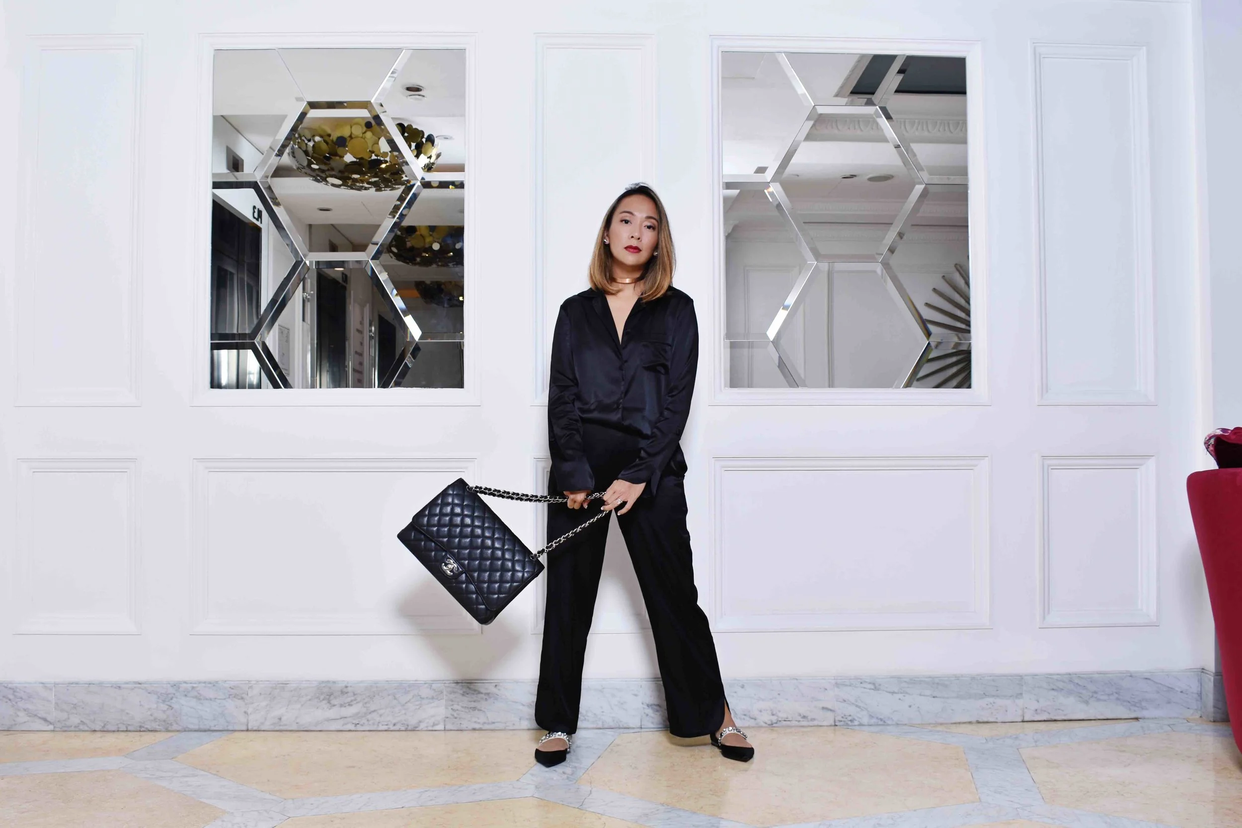Charmaine wears the EMMA Silk Jacket and MANON Silk Trousers in Black. Shoes and accessories all Charmaine's own