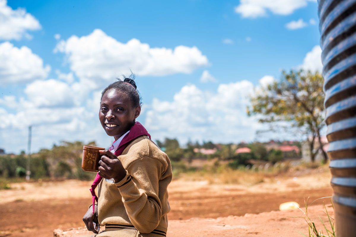 Impact-Water-Kenya-happy-female-student-with-water.jpg