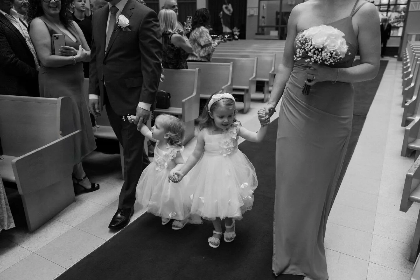 The aisle always feels bigger when you&rsquo;re small. One of my favourite candid aisle moments in black and white.