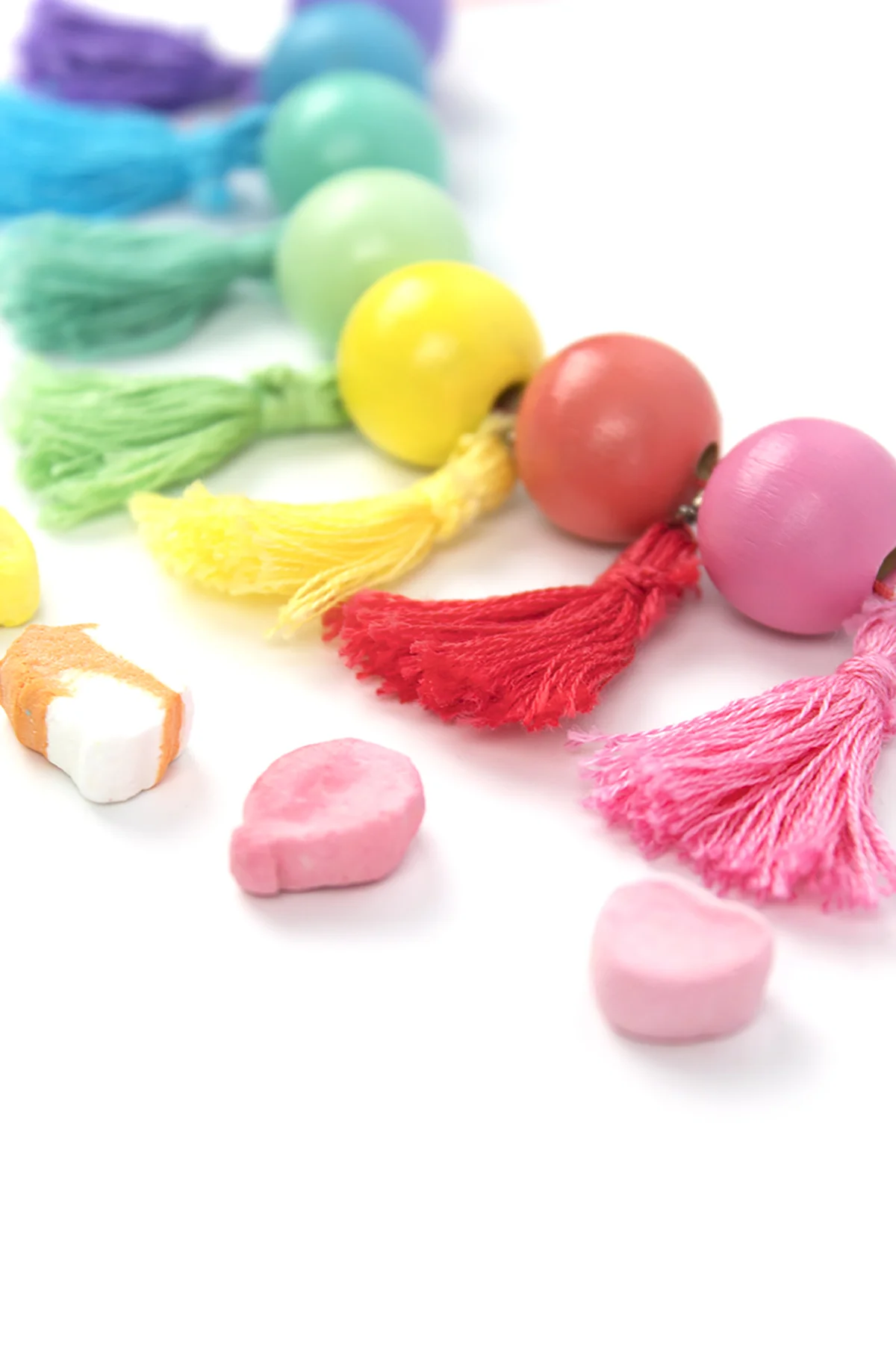 Add a little color to your wardrobe with this DIY Wood Bead Tassel Necklace. It features painted beads, DIY tassels, and a customizable palette. Make one for your closet today! #diyjewelry #rainbow #stpatricksday