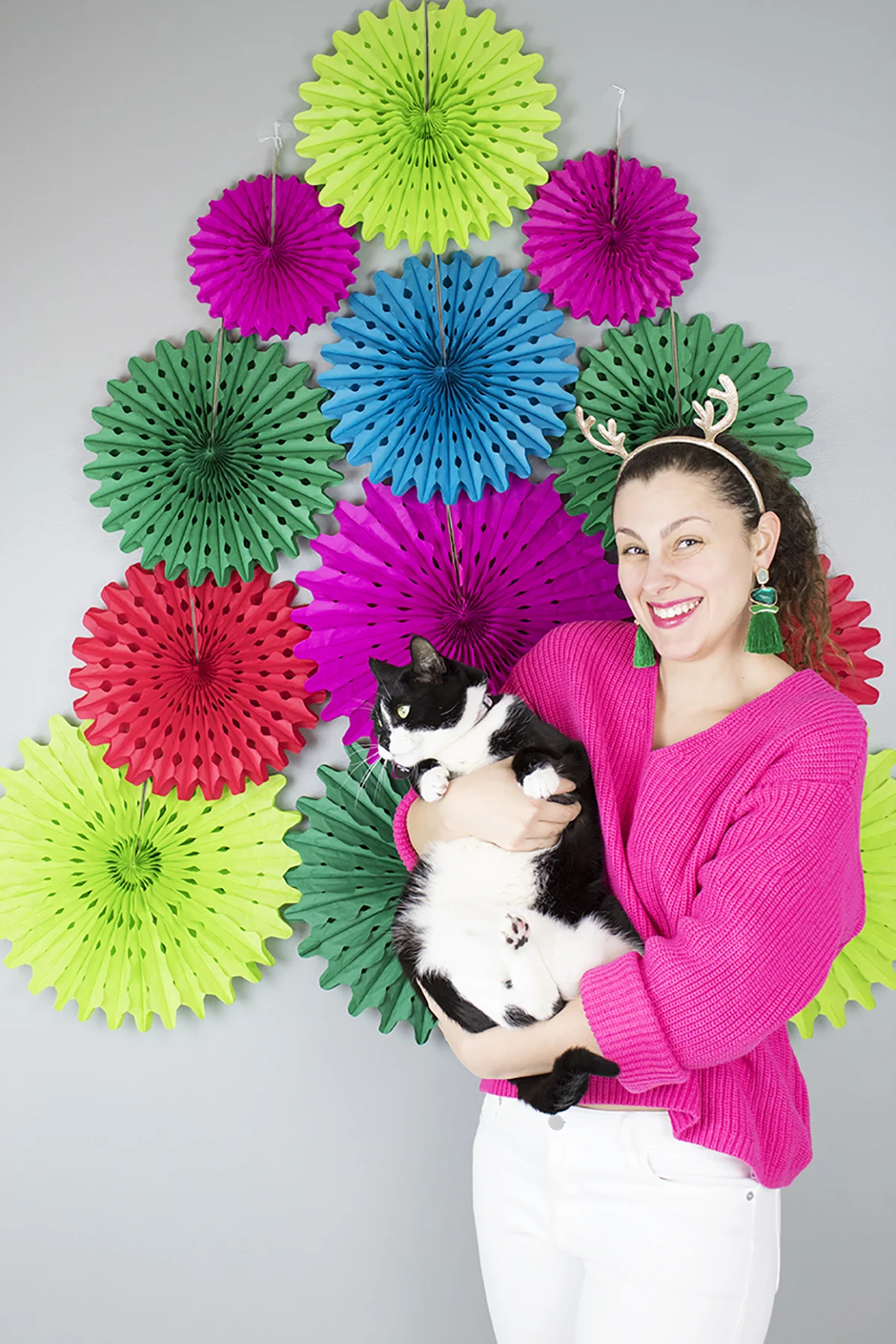 This DIY backdrop only takes a few minutes to put up, and it can be used again and again. It would look really cute starting lower and being a photo prop or even as a Christmas tree alternative for a small space. #paperfans #partybackdrops #christmastreealternative