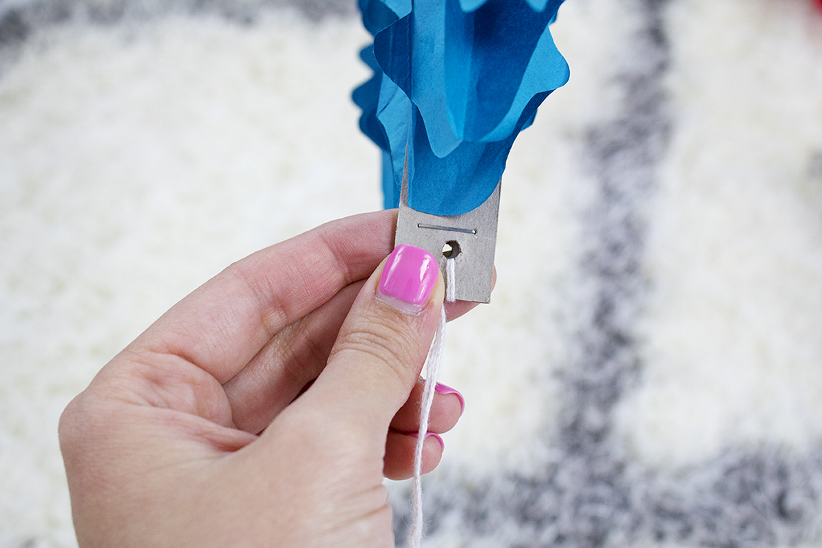 This DIY backdrop only takes a few minutes to put up, and it can be used again and again. It would look really cute starting lower and being a photo prop or even as a Christmas tree alternative for a small space. #paperfans #partybackdrops #christmastreealternative