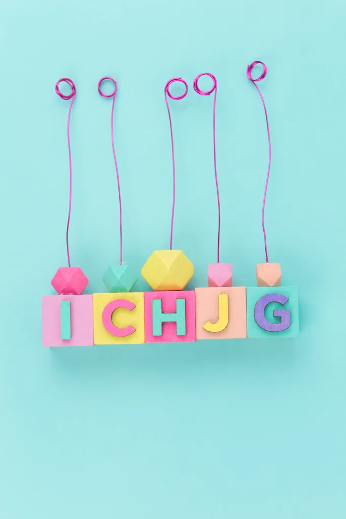 This summer, create a one of a kind experience for your guests by making them this DIY place card holder that doubles as a party favor. It’s really easy to make with only paint, wood blocks, and wire. You definitely want to whip this up before the summer ends! #placecard #diyplacecards #placecardholders