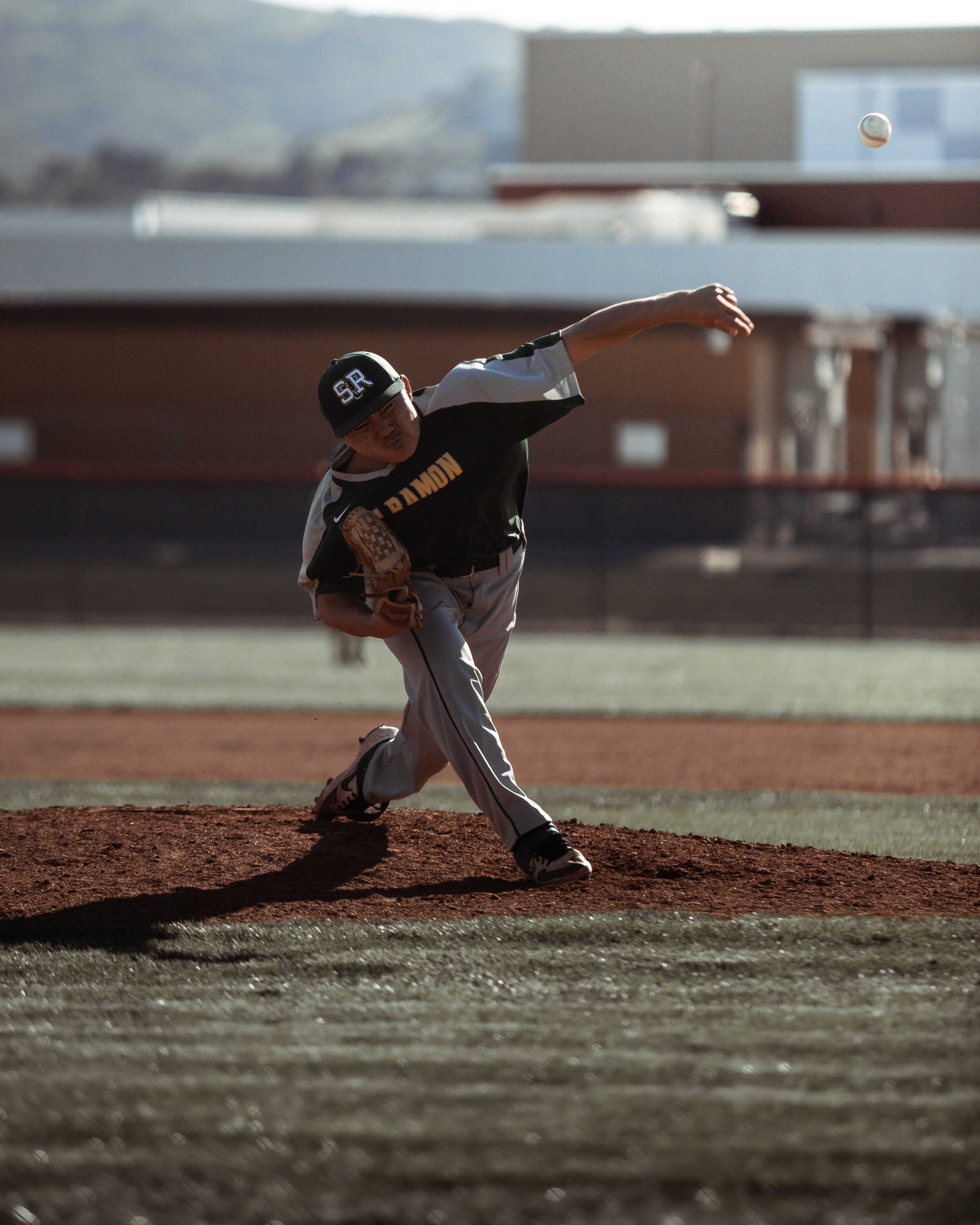 Baseball pitcher throwing a pitch on the mound during a game.