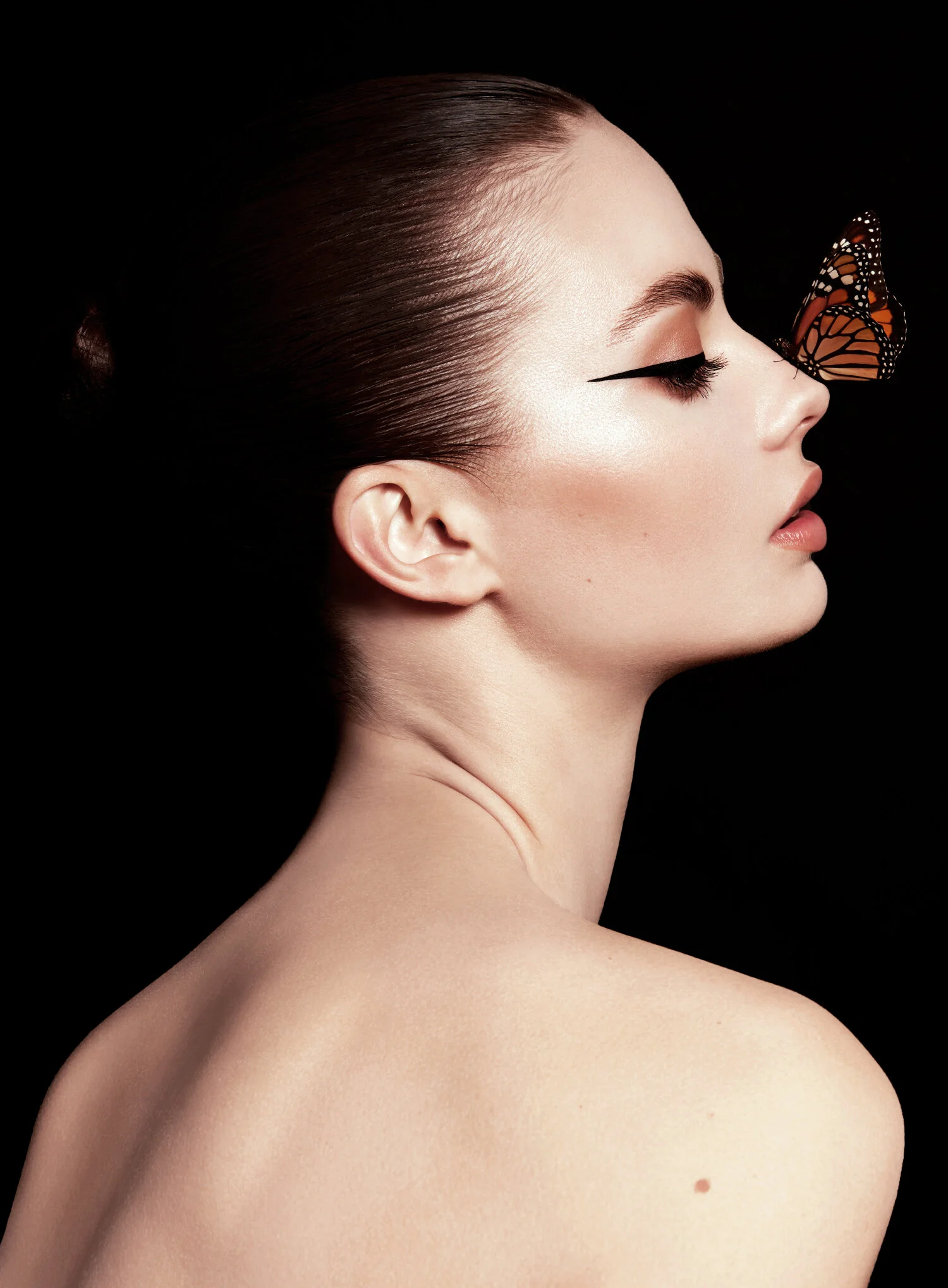los angeles new york beauty photographer natural dewy skin. High fashion model with monarch butterfly on her nose. Winged eyeliner