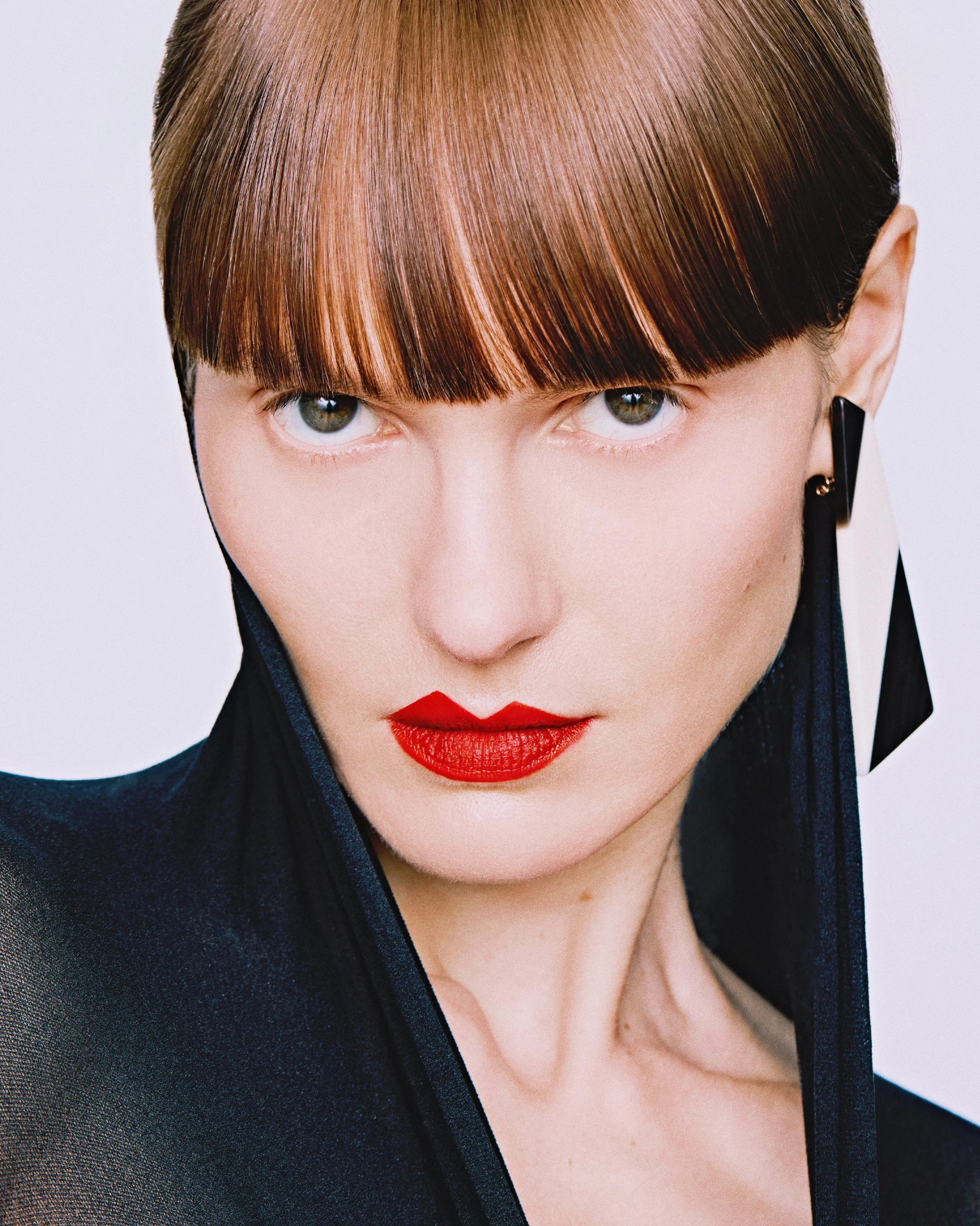 New York beauty photographer photoshoot makeup photography Top cosmetic photographers Model with pale skin asymmetrical red lipstick  Black and white earrings Los Angeles campaign