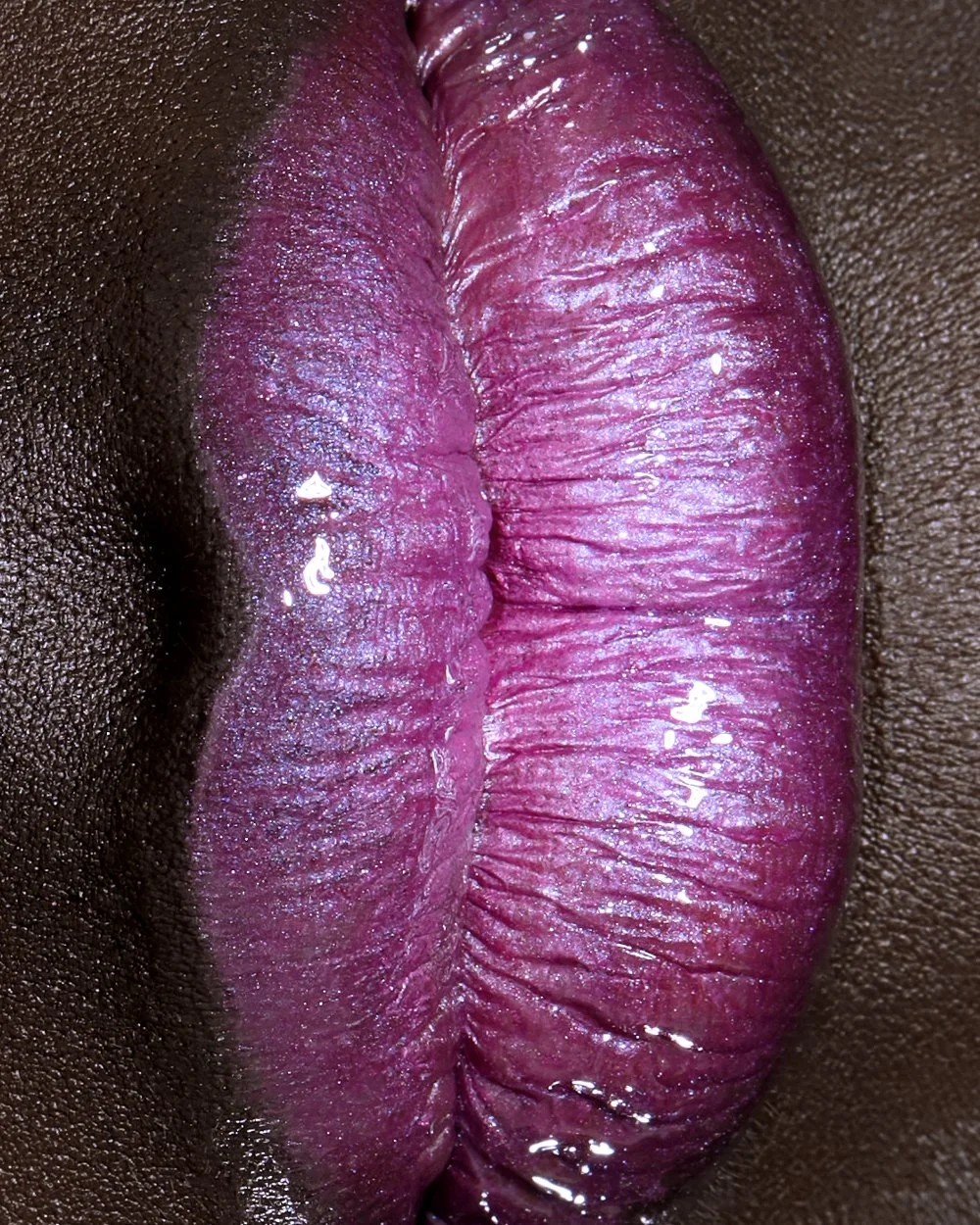 new york beauty photographer los angeles cosmetic photography makeup fashion pink eyeshadow deep dark skin skincare earrings lashes eyelashes top photographers lip macro purple lipstick gloss shine