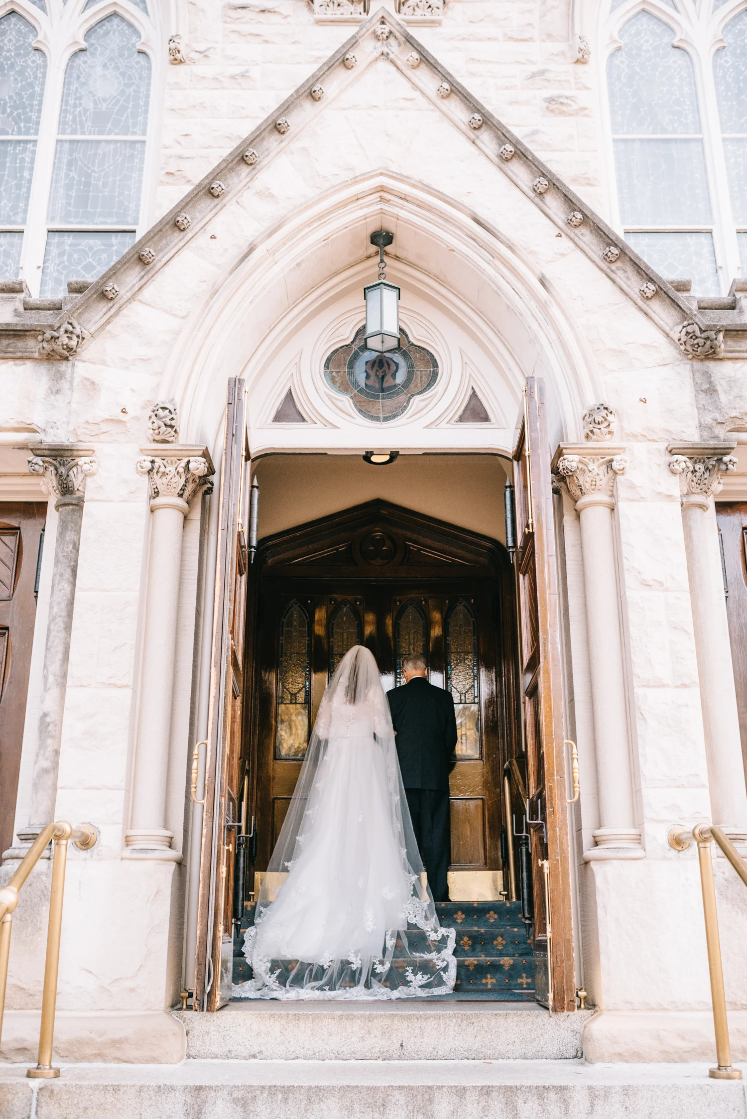 father and bride walk into church to go down the aisle