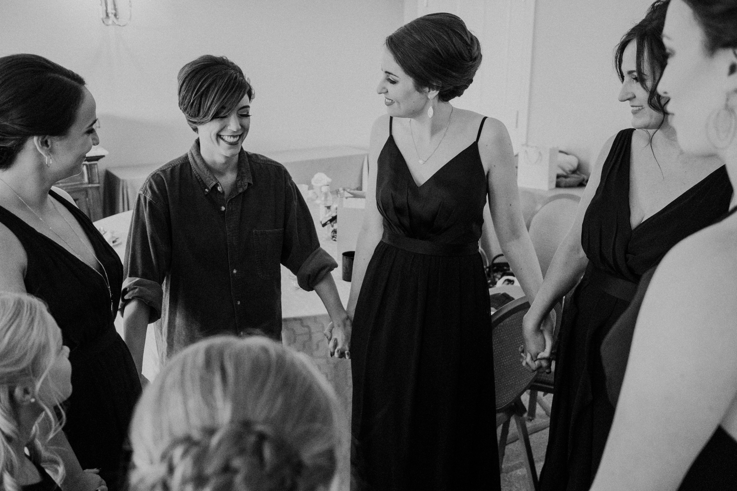 bridesmaids circle up and hold hands before wedding