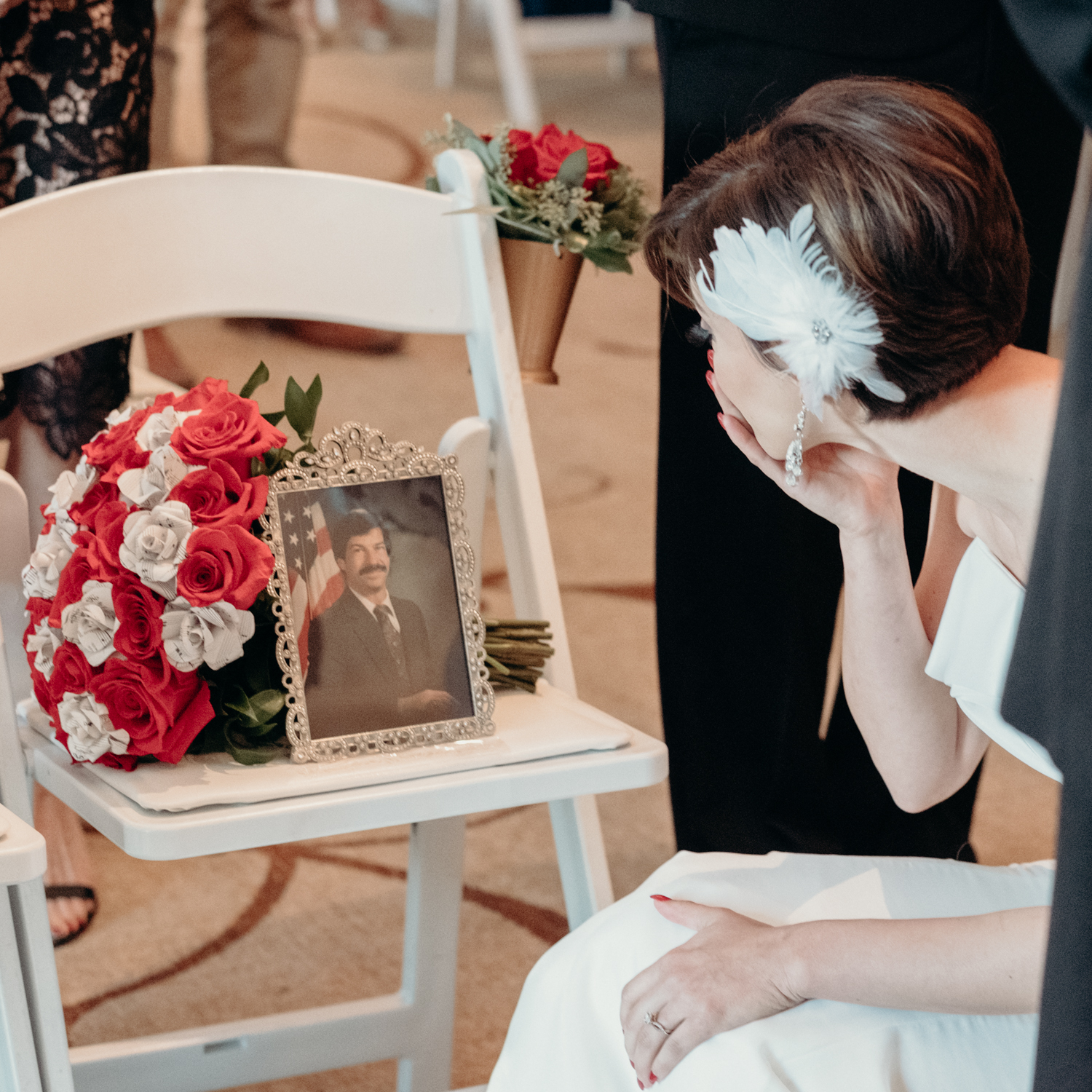 bride stops to kiss the picture of her late father before the start of wedding ceremony