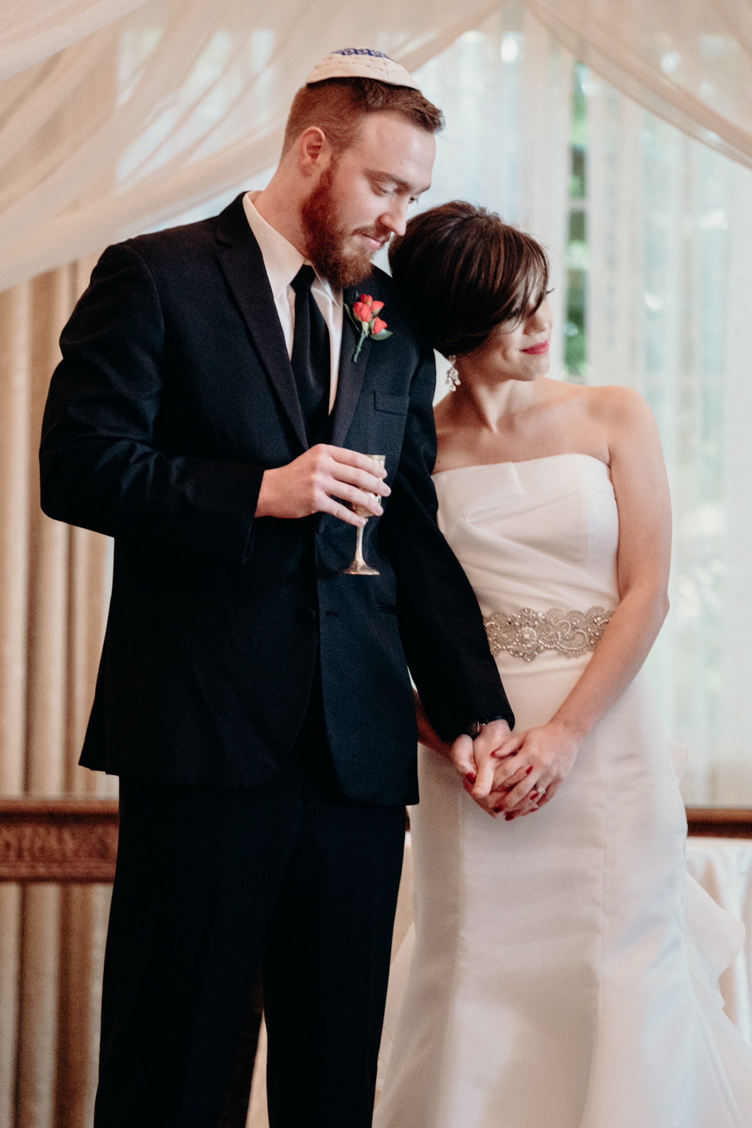 bride and groom during wedding ceremony listen to rabbi