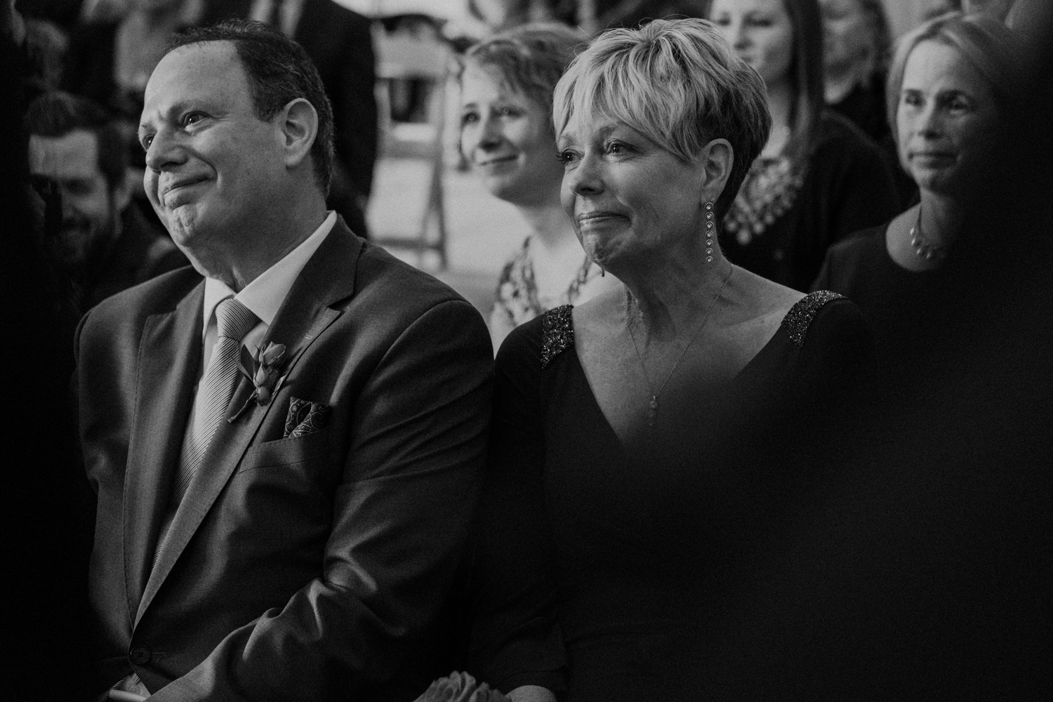 Groom's parents listen on with tears in eyes as they're son reads his vows