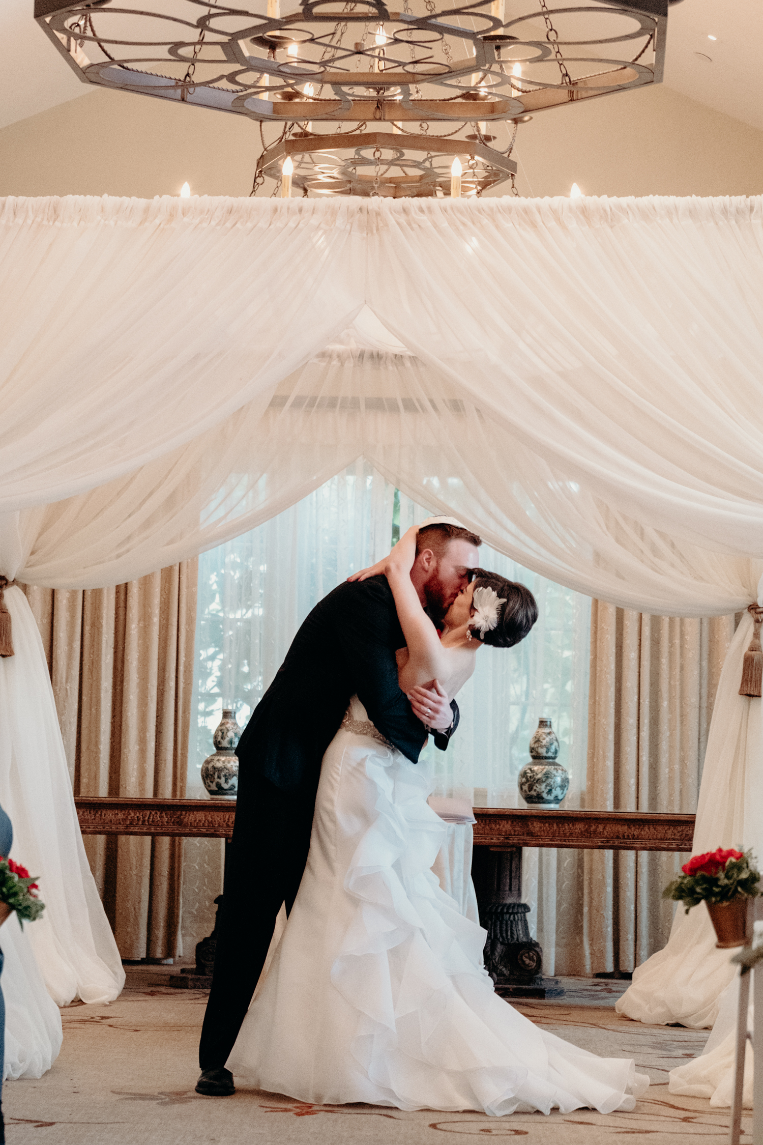 bride and groom kiss after breaking the glass