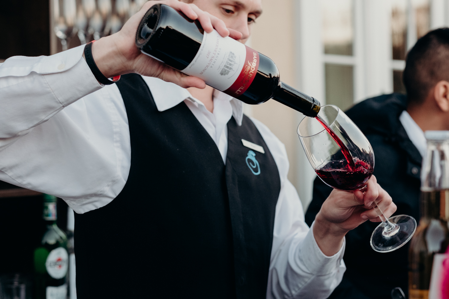 bartender pours wine for guests during virginia wedding cocktail hour