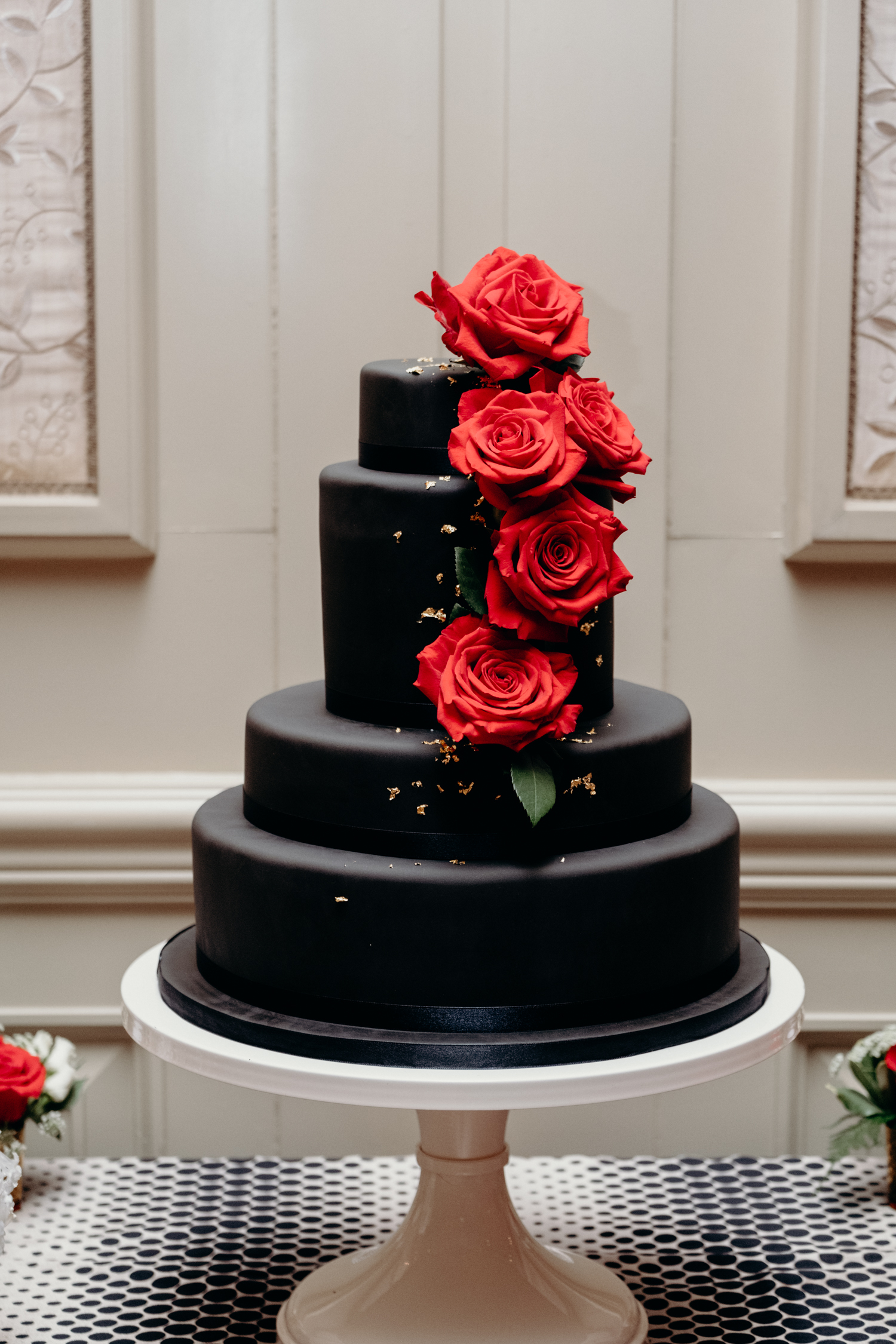 black and gold cake with red roses at virginia wedding