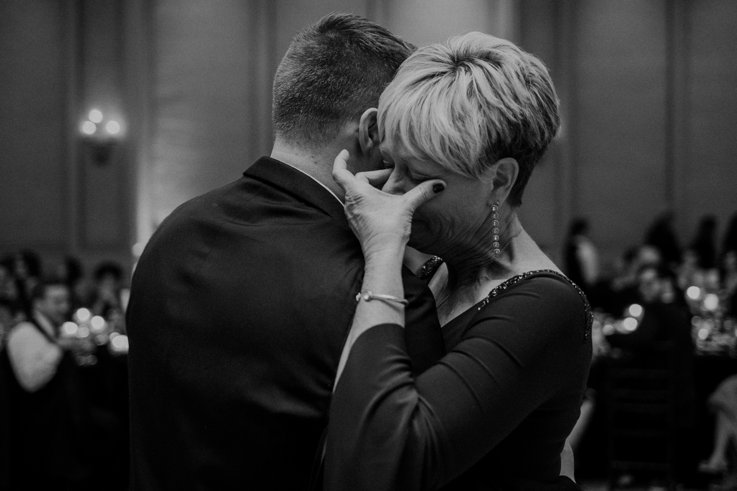 mother of groom wipes tears from her eyes during mother son dance at virginia wedding