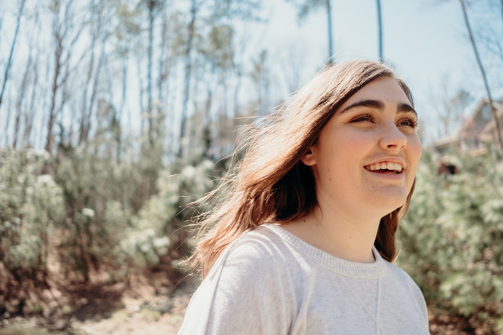 A senior in high school laughs while her hair is blown in the wind during her photo session in North Carolina.