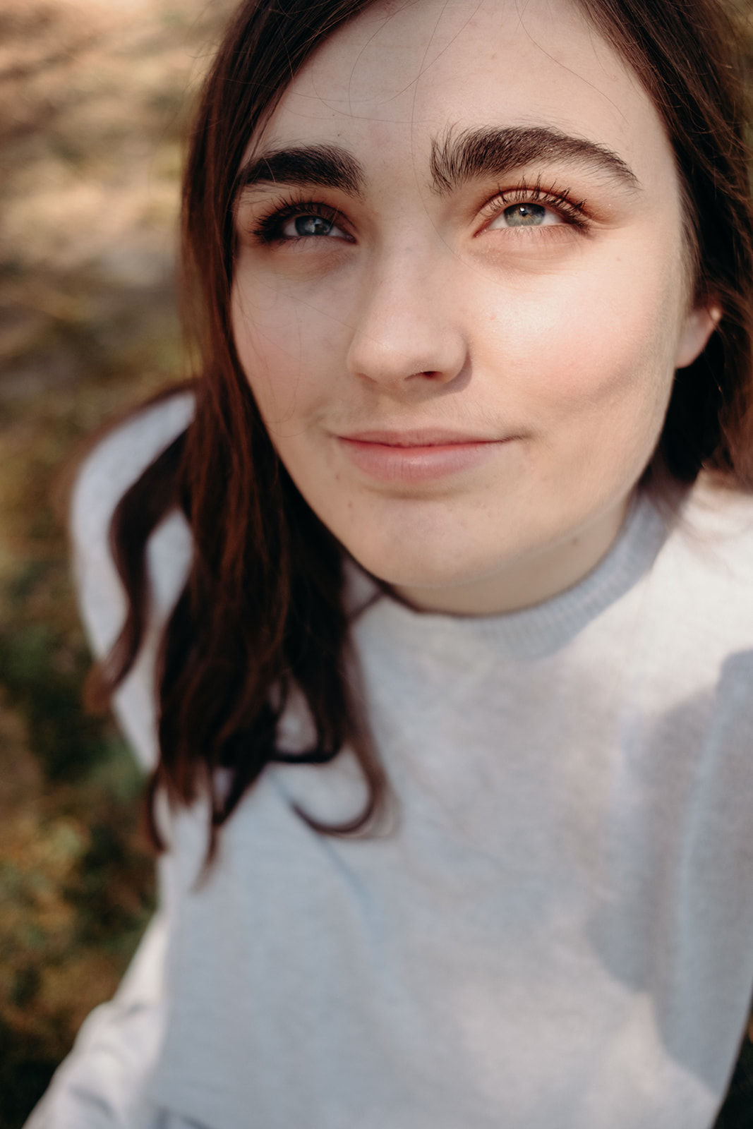 A girl looks up into the sunlight during her senior portrait shoot in North Carolina. 