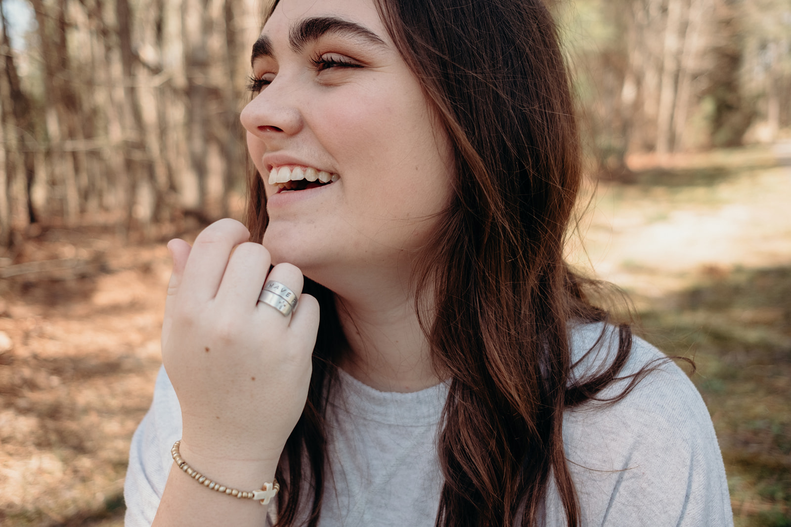 A girl brushes the hair out of her face during her senior portrait photo session in North Carolina. 