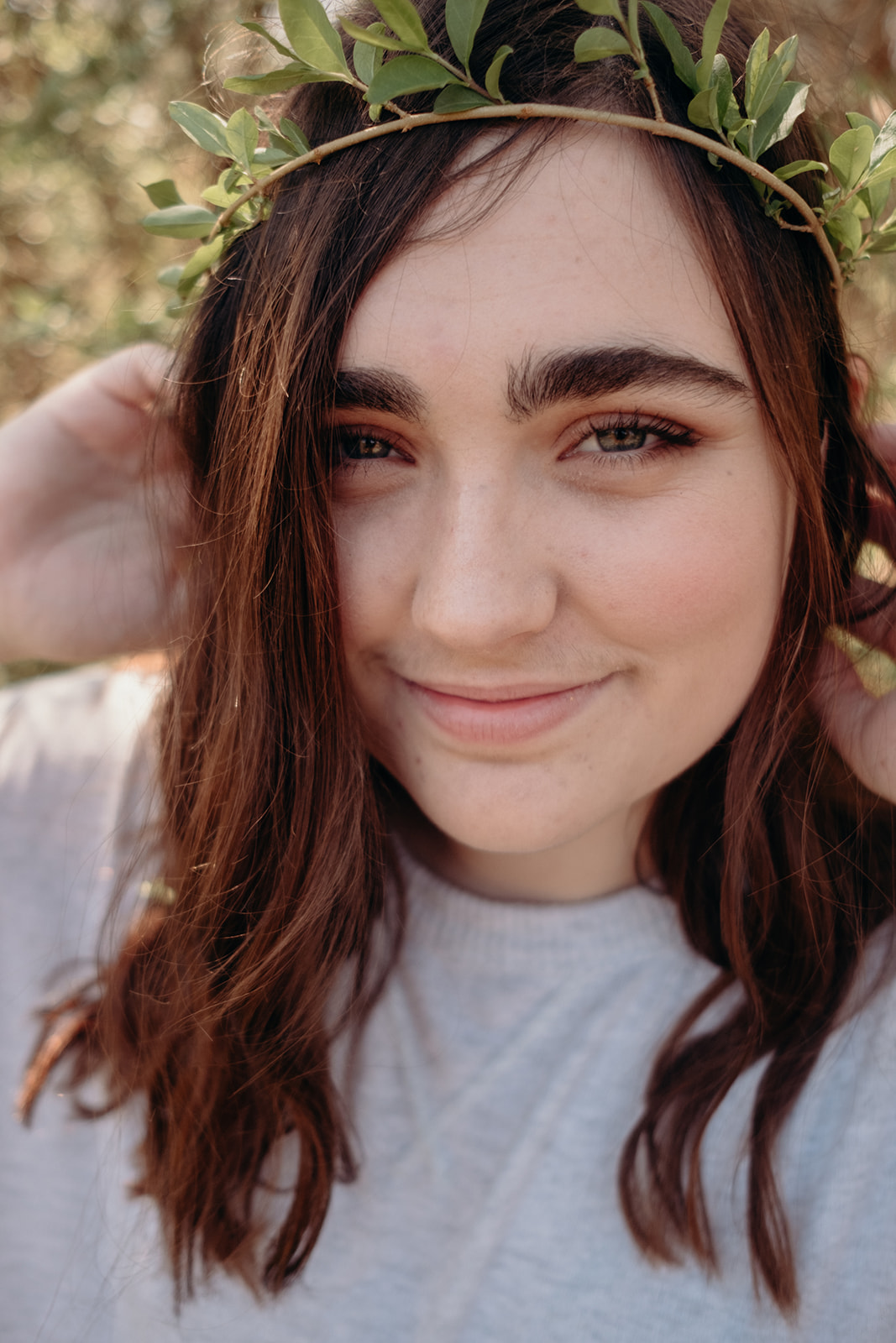 A girl wears a leafy springtime crown of green during her senior portrait session in North Carolina.  