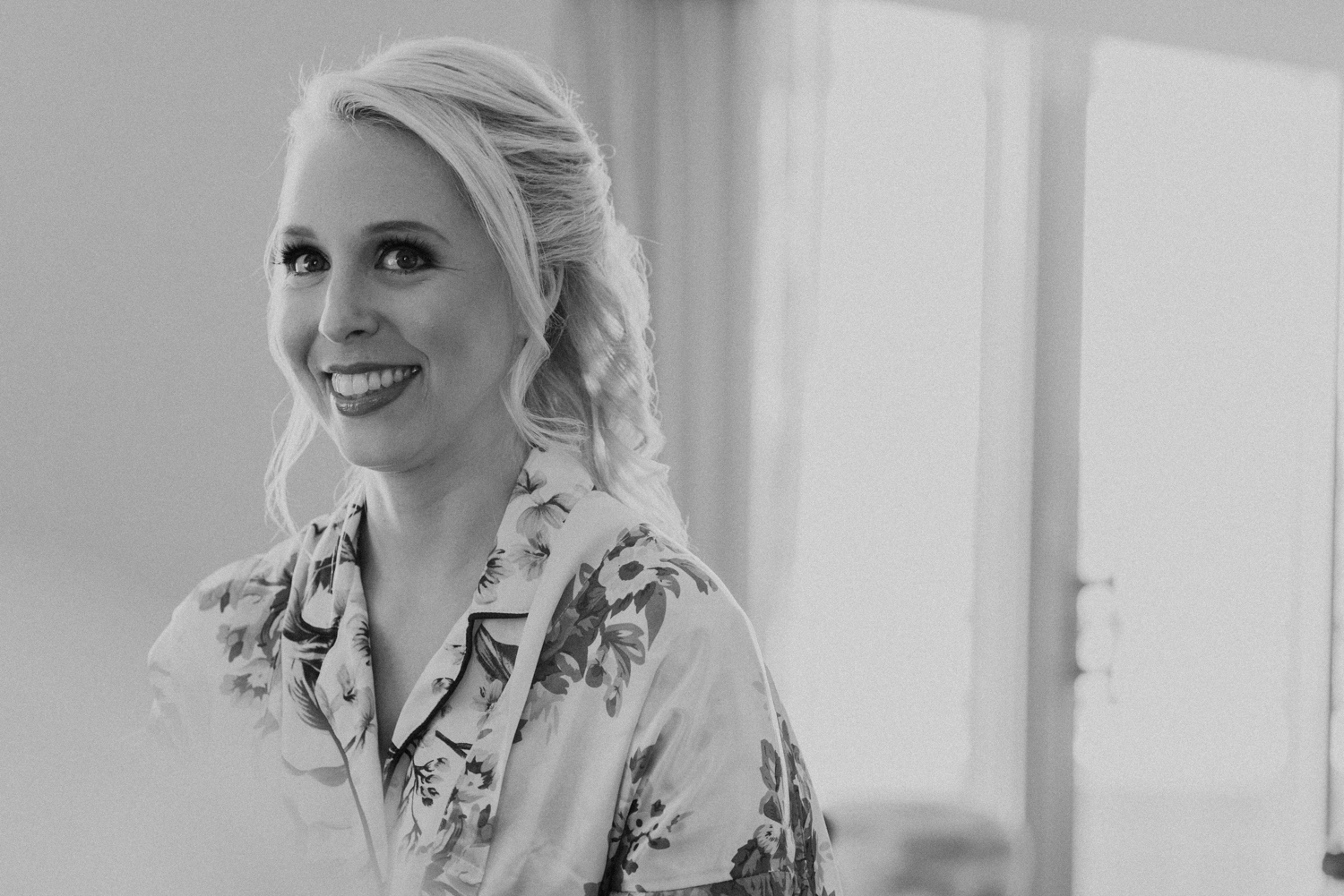 A bride smiles after finishing getting her hair and makeup done on her wedding day at Lansdowne Resort.