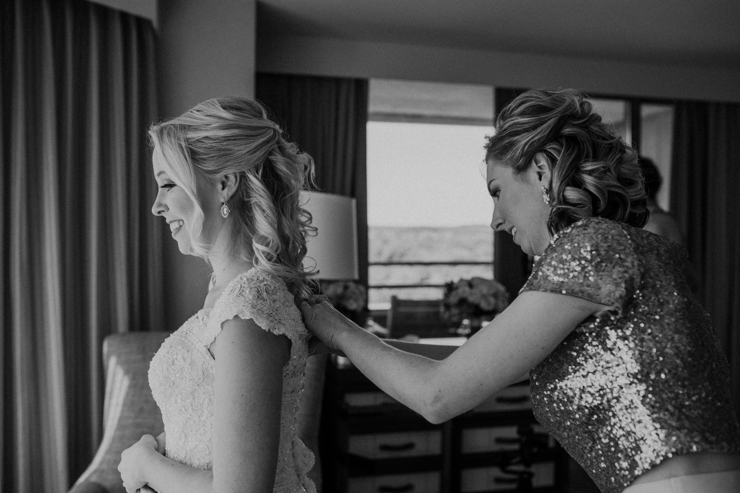 A maid of honor helps the bride get her dress on for her wedding day at Lansdowne Resort.