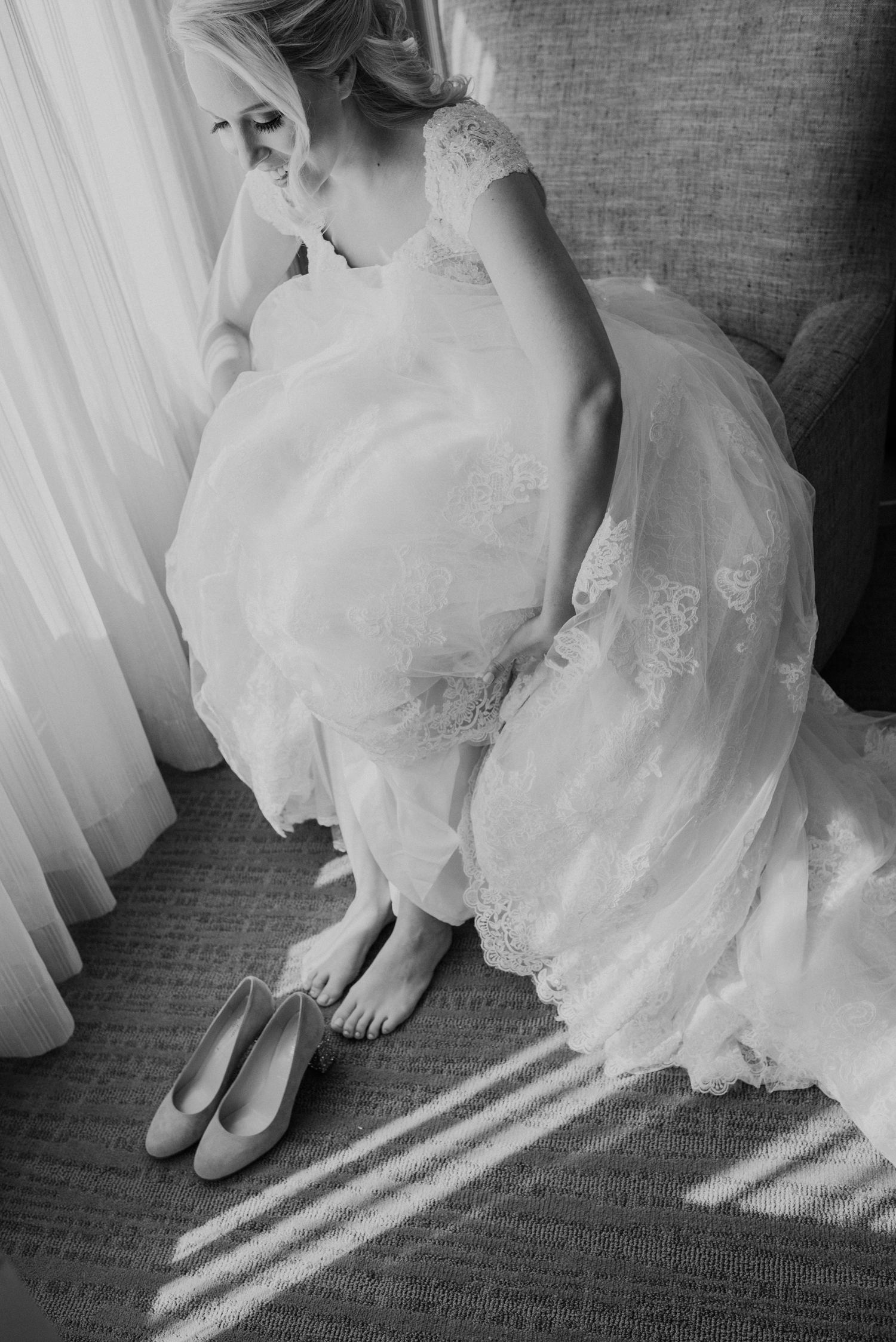 A bride gets ready to put on her shoes before her wedding day at Lansdowne Resort.