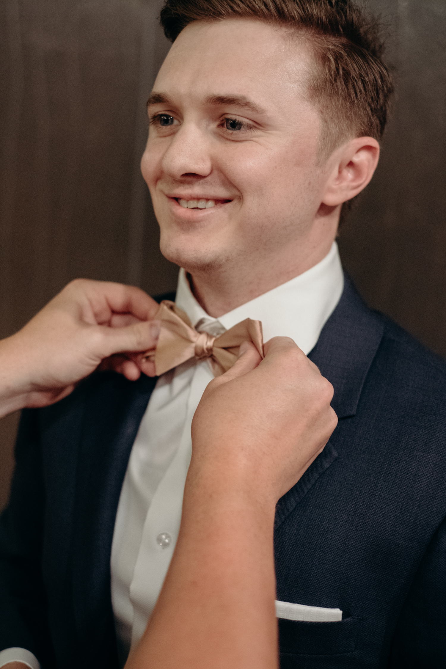 A groom gets his bowtie checked by a groomsman before he walks down the aisle at his wedding at Lansdowne Resort.