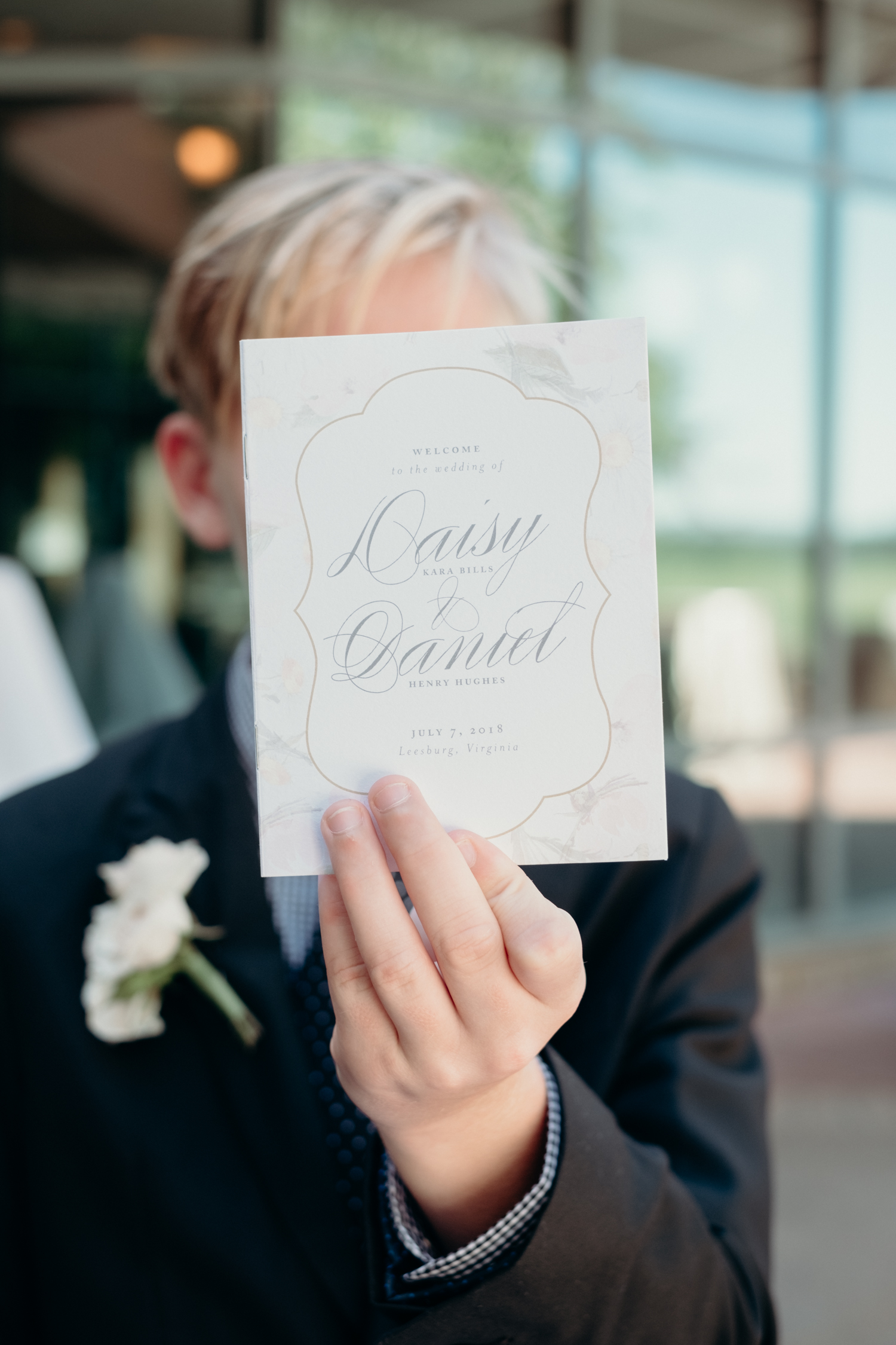 A boy holds up the program for a wedding ceremony at Lansdowne Resort.