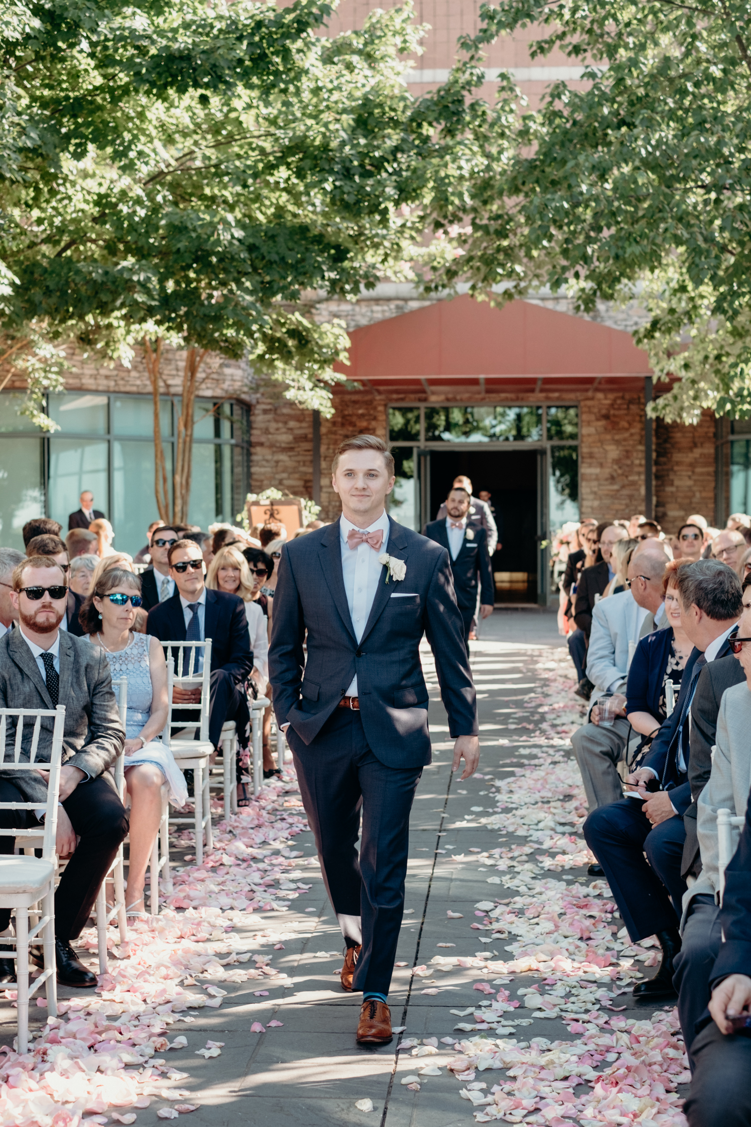 A groom walks up an aisle strewn with petals for this wedding ceremony at Lansdowne Resort.