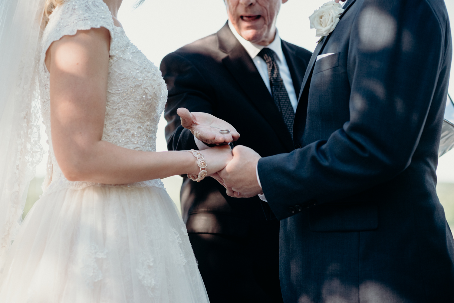 An officiant hands the bride and groom their rings during a ceremony at Lansdowne Resort.