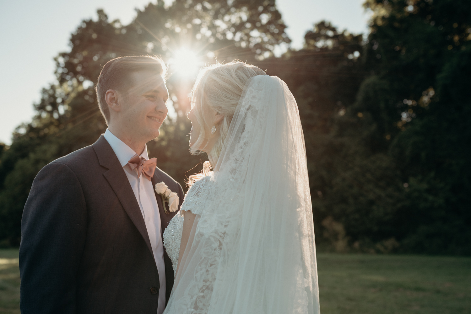 The sun shines through while a husband and wife gaze at each other after their outdoor wedding ceremony at Lansdowne Resort.