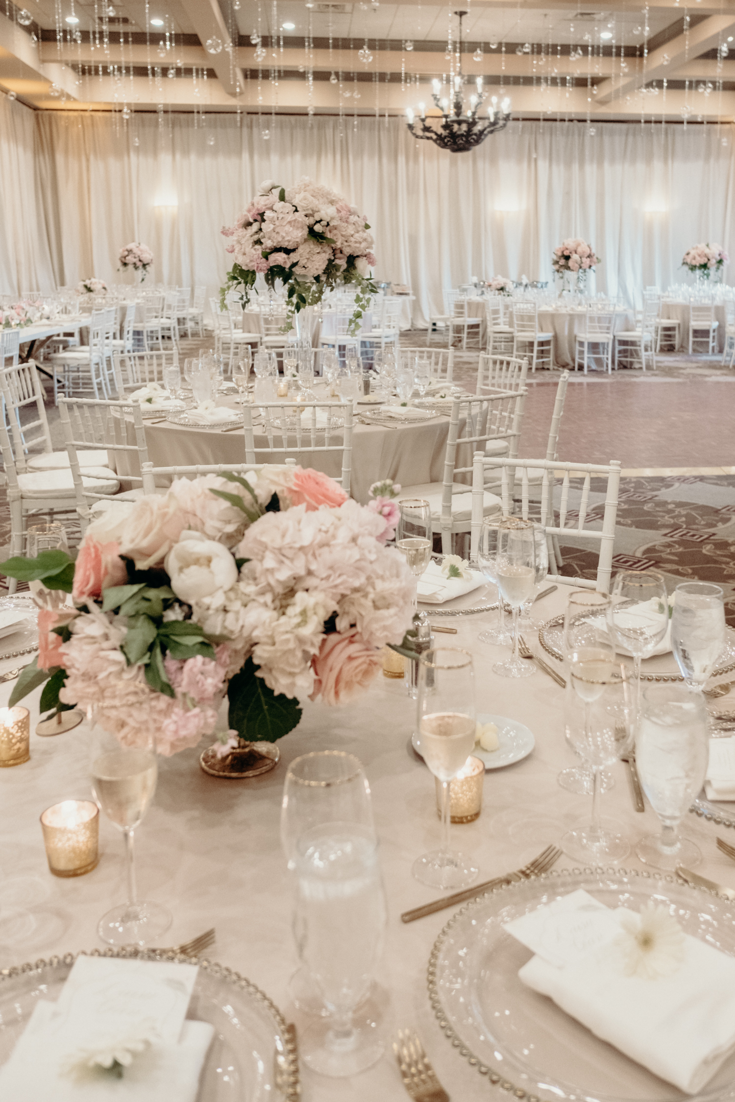 A ballroom at Lansdowne Resort is decorated in whites and creams and pinks with crystals dripping from the ceiling. 
